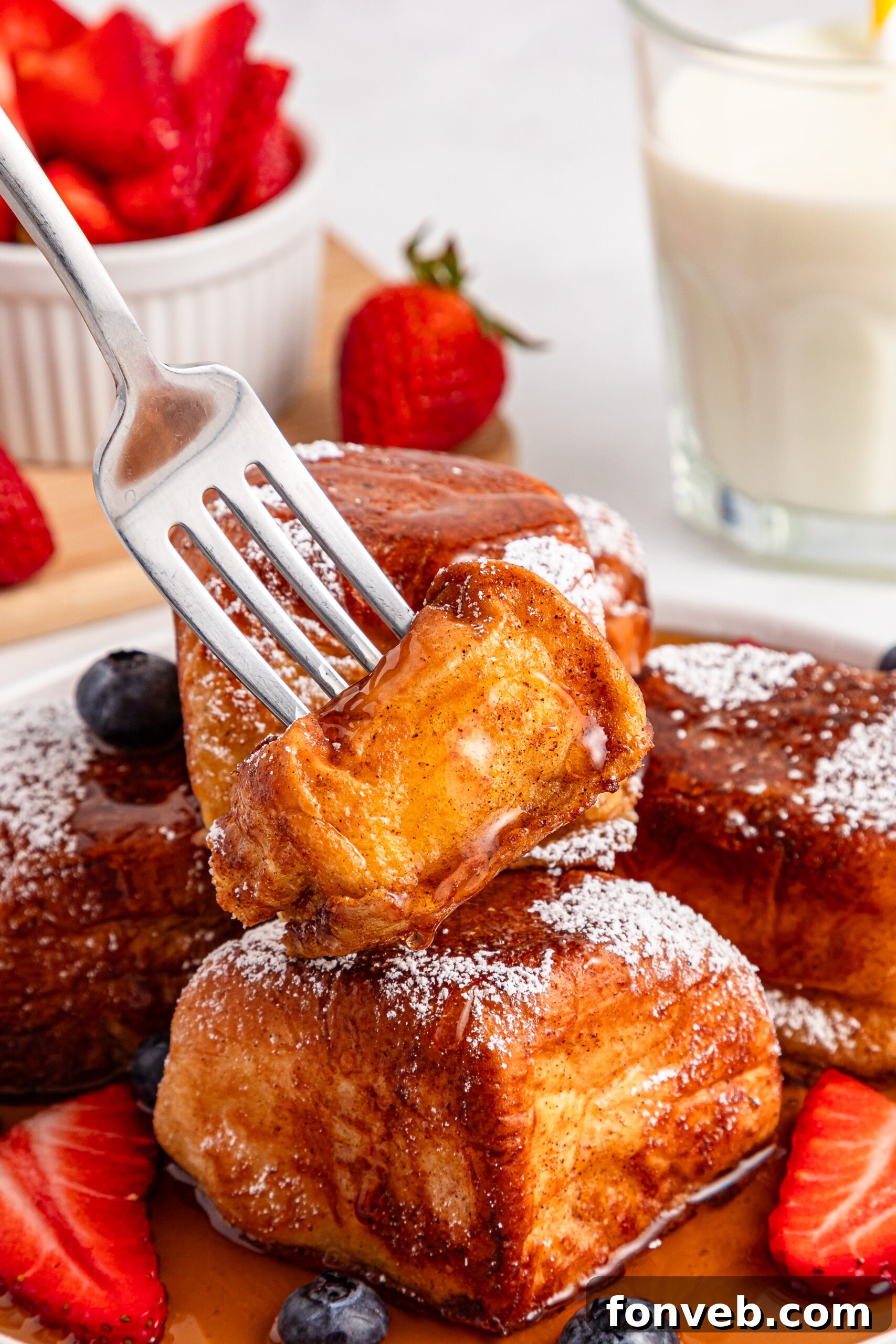 syrup on top of the Hawaiian Roll French Toast with a fork lifting a bite