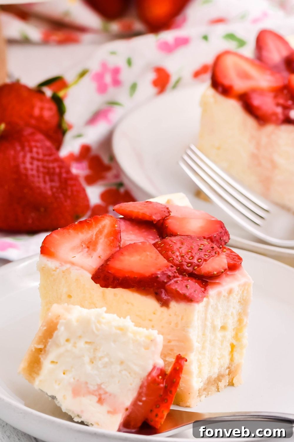 slice of cheesecake on a plate with a fork and some cheesecake on the fork 