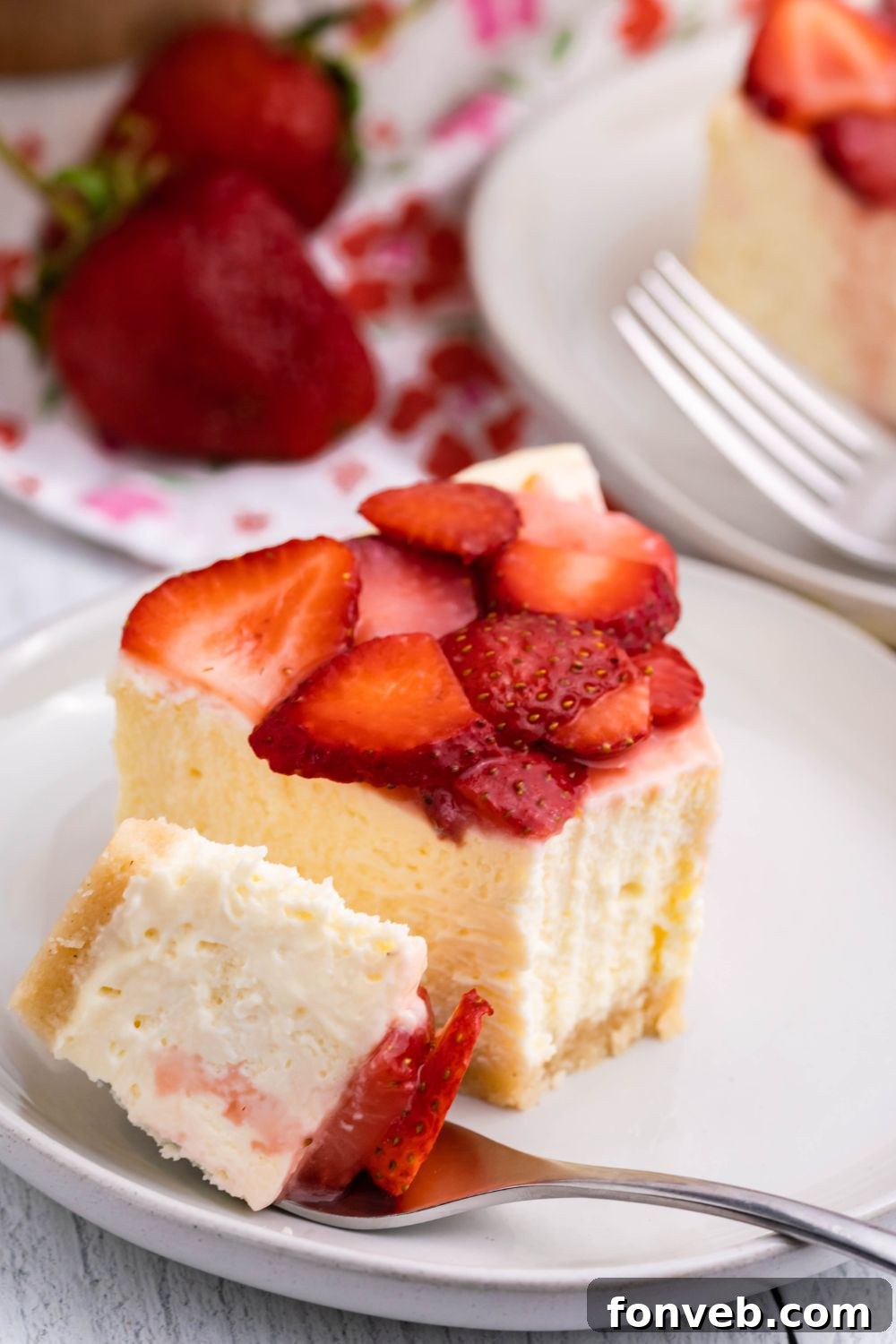 slice of keto cheesecake on plate with a bite of it on the side with a fork