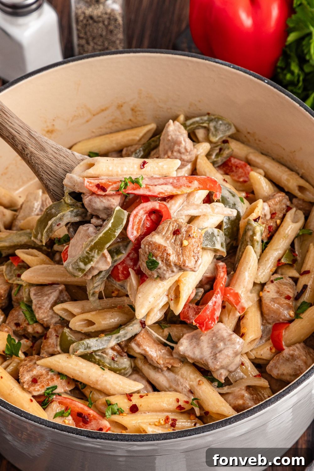 Reggae Ragu 16 cooked Rasta Pasta in a stockpot with some scooped out with a wooden spoon