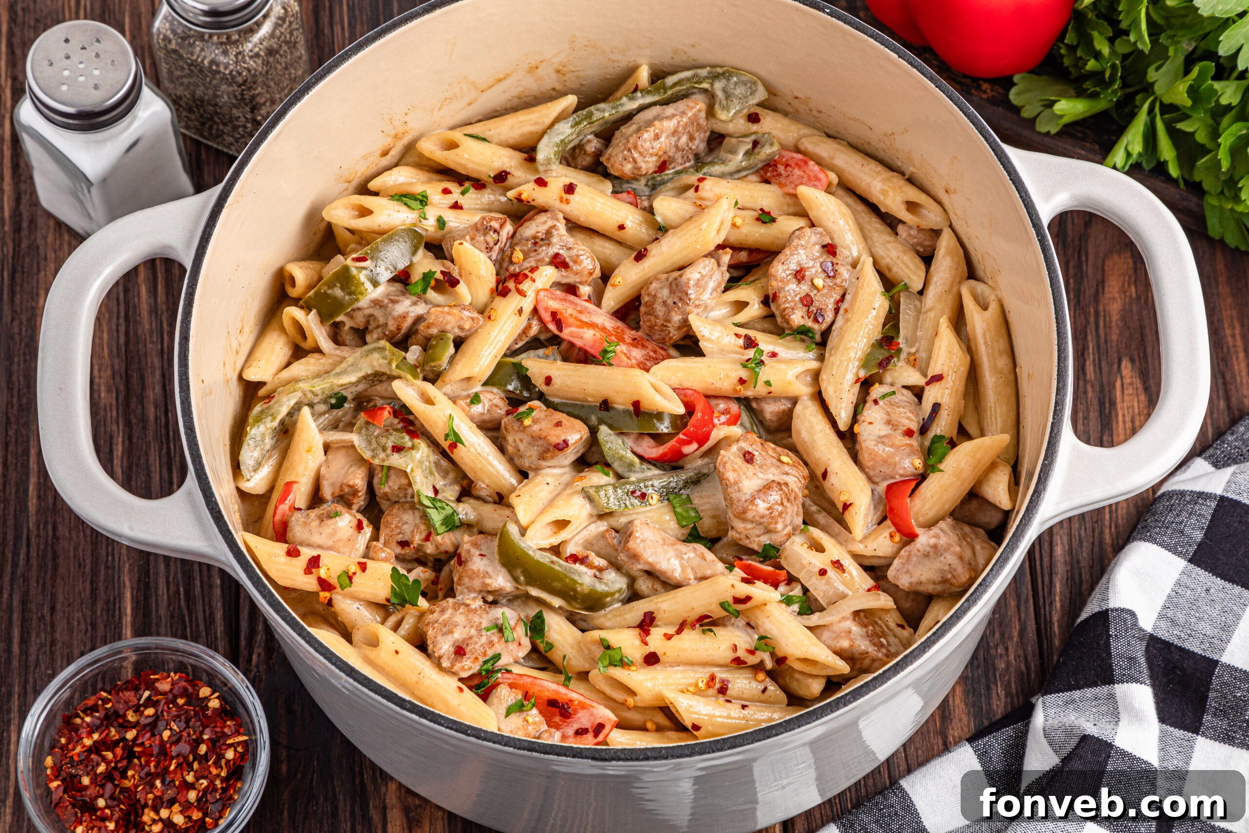 Reggae Ragu 7 up close view of the Rasta Pasta in a large pot on a dark wooden table with salt and pepper shakers in the photo