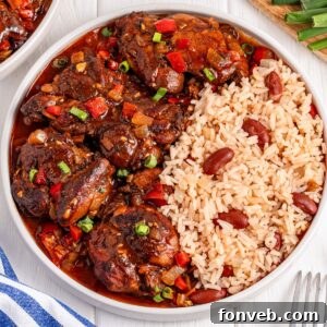 Jamaican Brown Stew Chicken and rice and beans on a plate on table