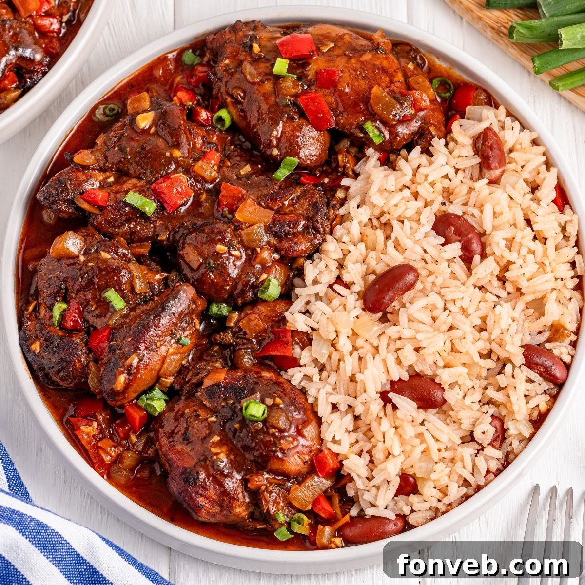 Jamaican Brown Stew Chicken and rice and beans on a plate on table 