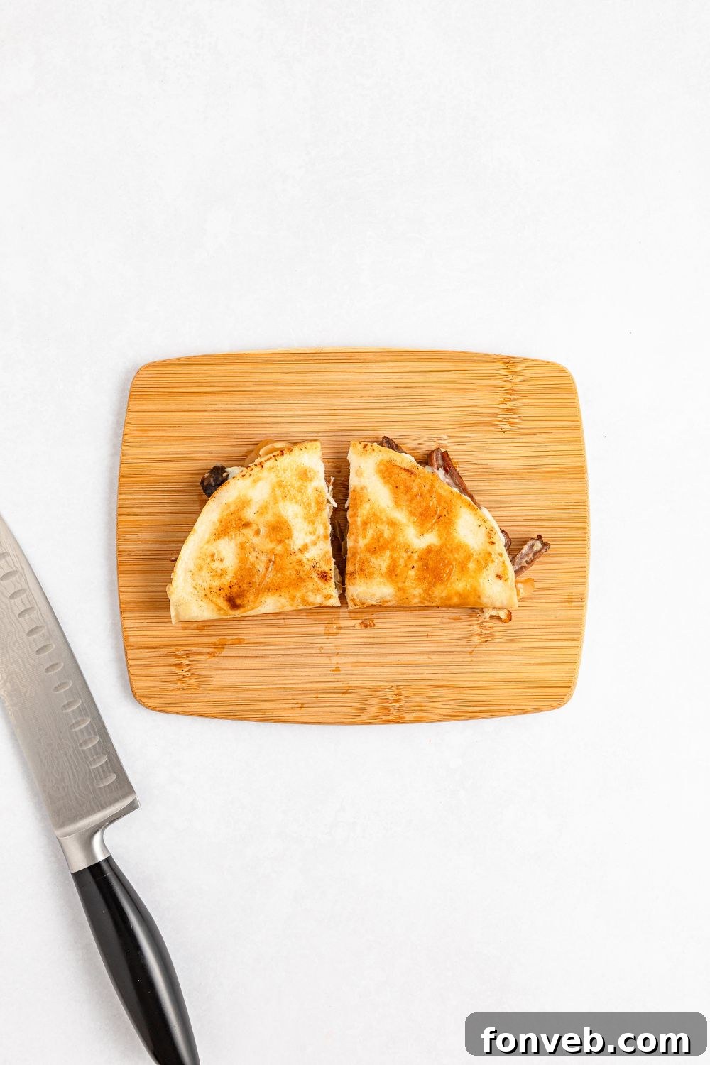 Hearty Mississippi Melt Quesadillas 14 Mississippi Pot Roast Quesadilla on a cutting board with a slice in half