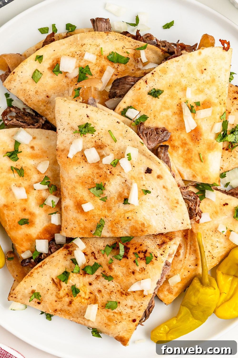 Hearty Mississippi Melt Quesadillas 18 Mississippi Pot Roast Quesadillas spread out on table with some peppers