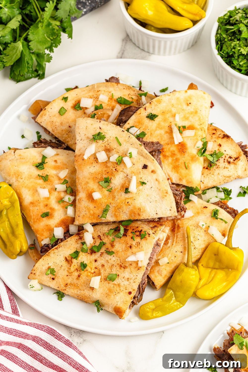 Hearty Mississippi Melt Quesadillas 8 Mississippi Pot Roast Quesadillas piled on a plate with pepperocinni peppers around it