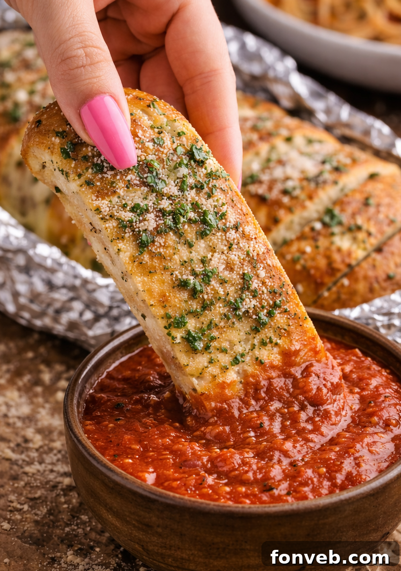 Homemade Pizza Hut Breadsticks 8 Copycat Pizza Hut Breadstick being dipped into a cup of marinara sauce