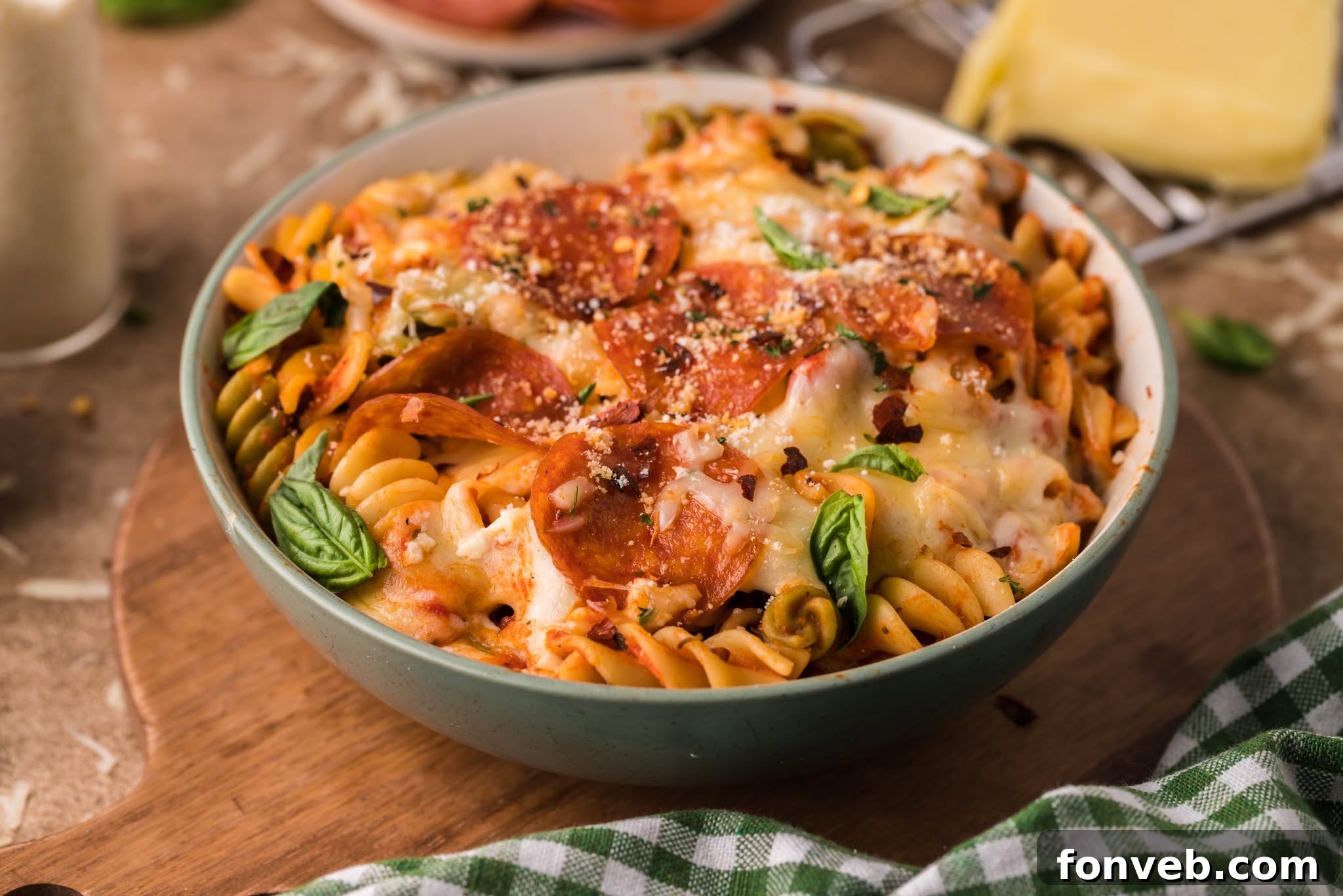 Cheesy TikTok Pizza Pasta Bake 5 Tik Tok Pizza Pasta Casserole in a green bowl topped with parmesan cheese