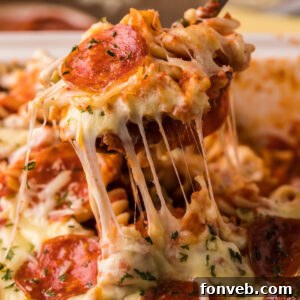 Cheesy TikTok Pizza Pasta Bake 7 TikTok Pizza Pasta Casserole bite being lifted up with a serving fork