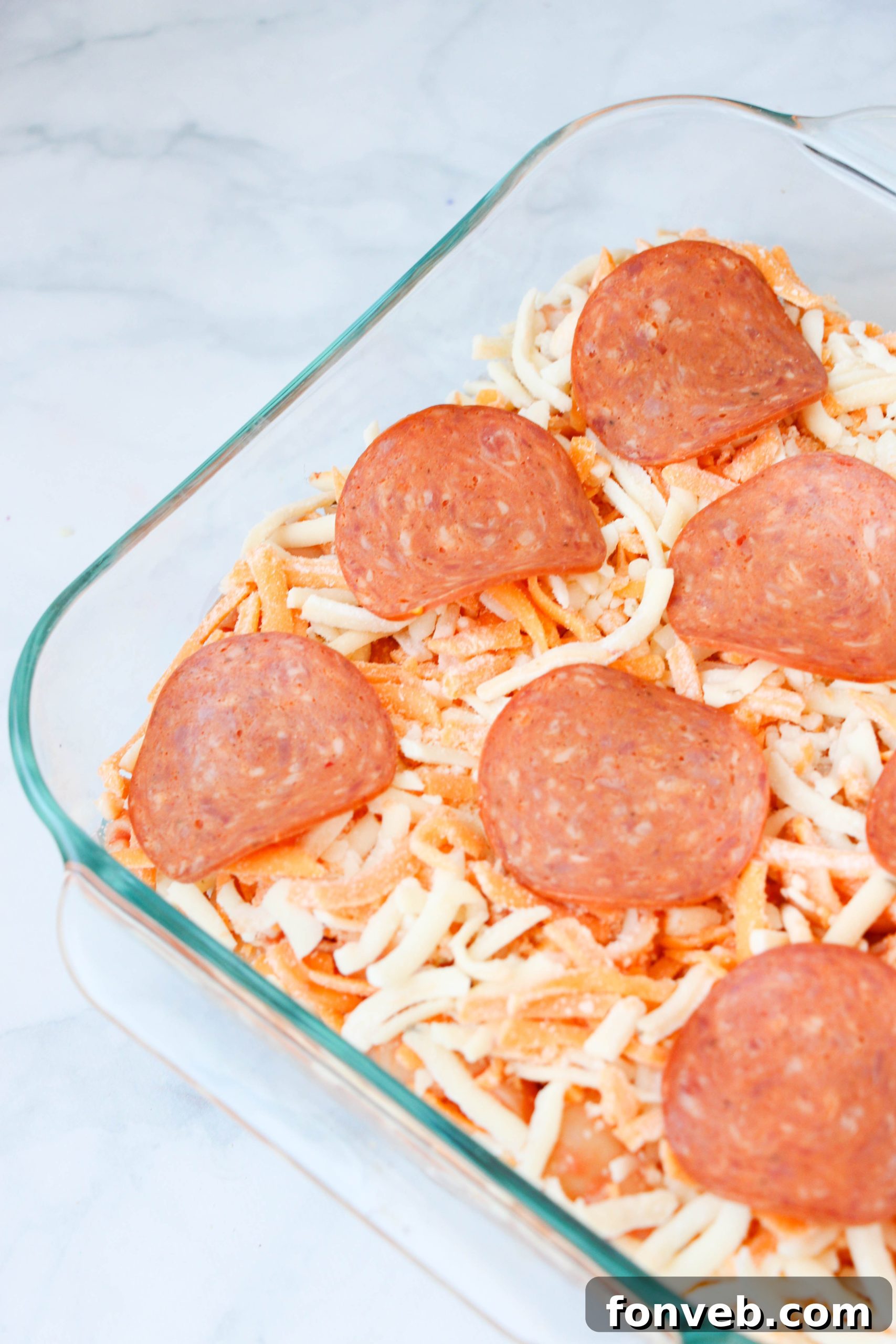 Close-up of Pepperoni Pizza Pasta Bake ingredients being mixed in a bowl
