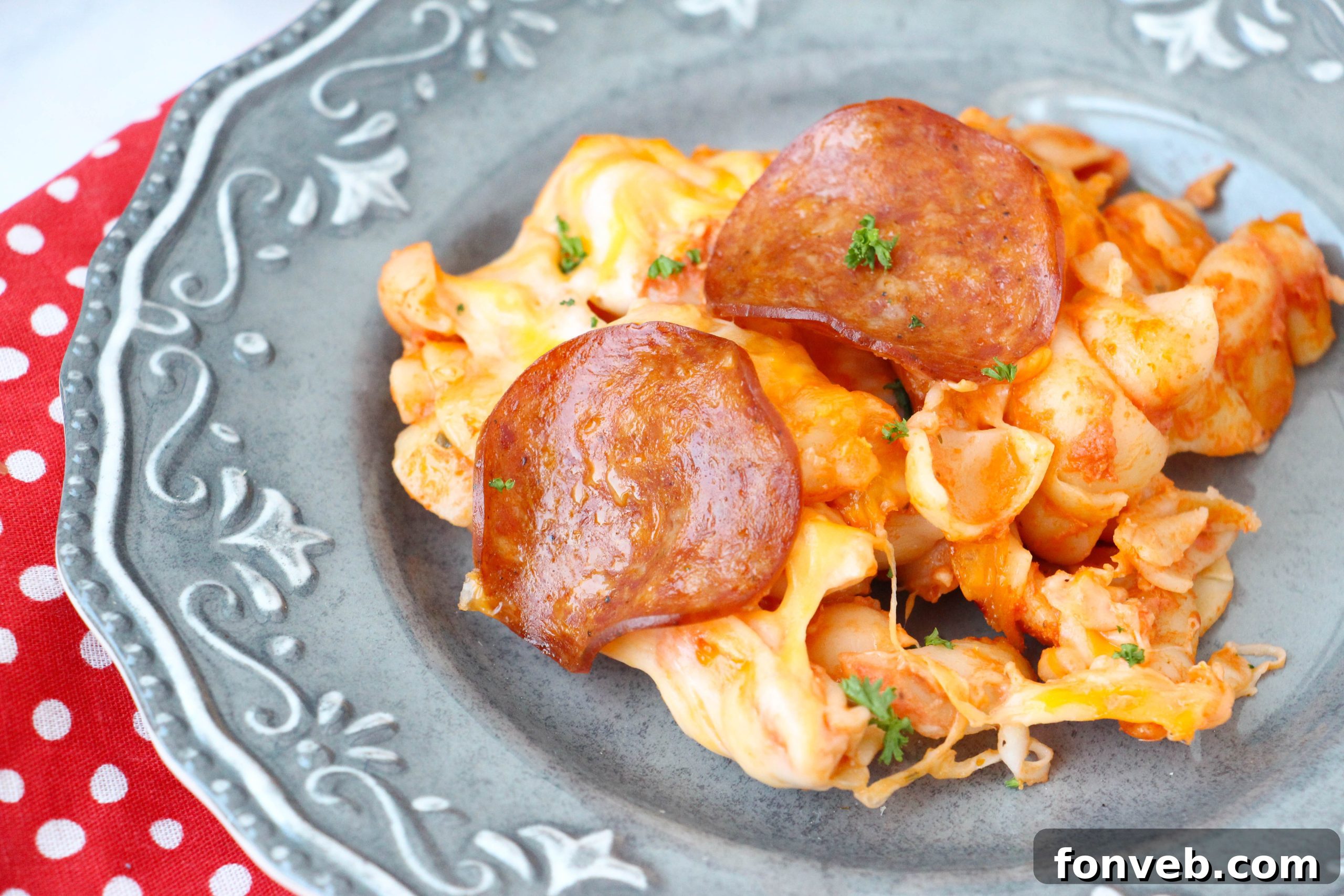 Pasta and sauce being combined in a large bowl during the preparation of the dish