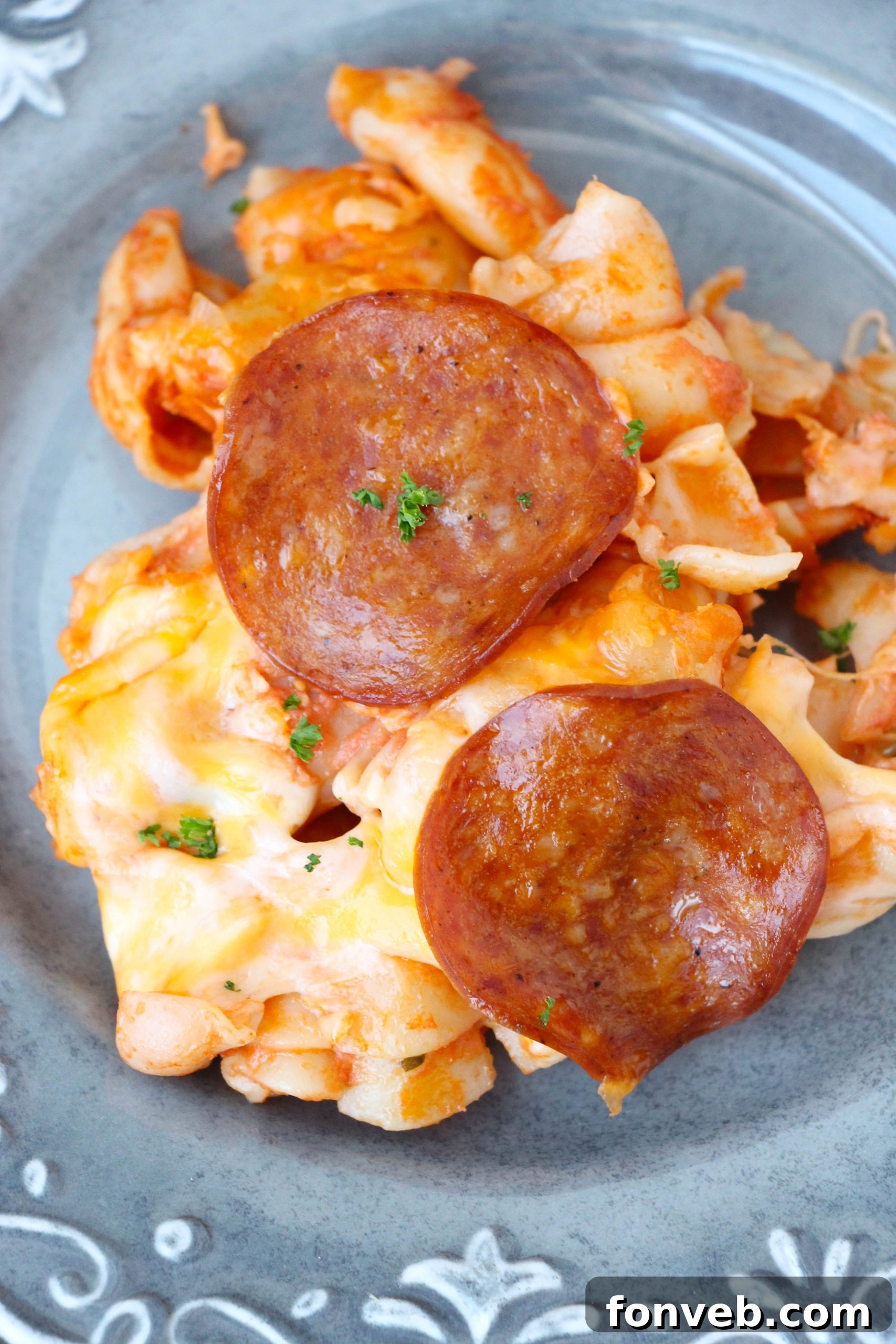 Individual serving of Pepperoni Pizza Pasta Bake on a plate, garnished with fresh parsley