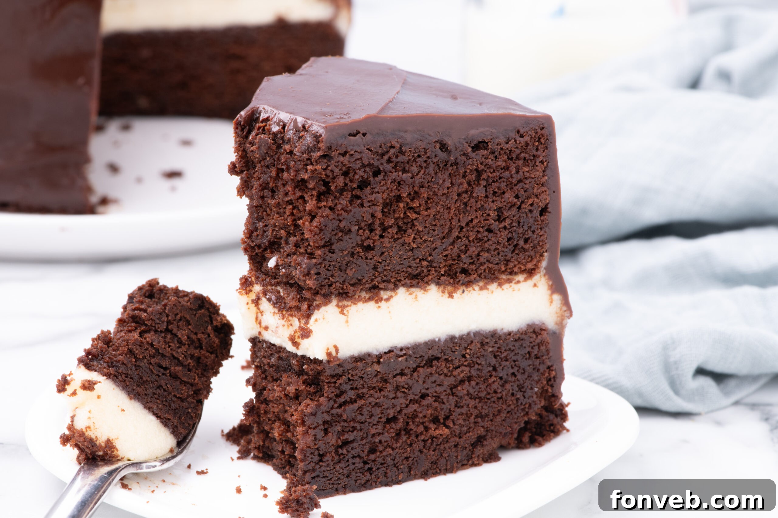 Decadent Chocolate Cream Dream 11 A delightful slice of Ding Dong Cake on a white plate, with a fork holding a tantalizing bite, ready to be savored.