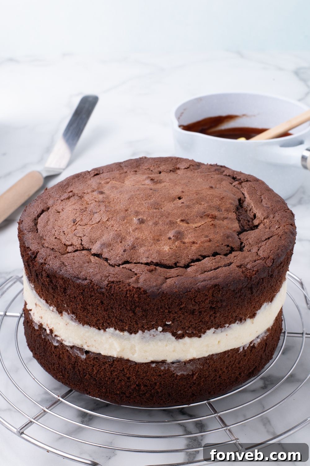 Decadent Chocolate Cream Dream 17 An unglazed, layered Ding Dong Cake sitting on a tray, demonstrating the assembly process of the cake before its final chocolate coating.