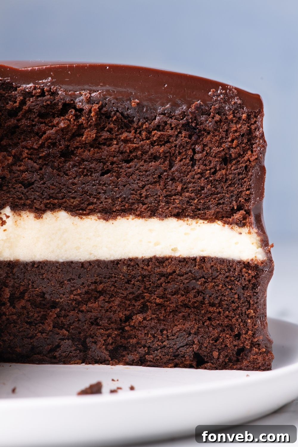 Decadent Chocolate Cream Dream 20 A delectable Ding Dong Cake with a slice artfully removed, elegantly showcased on a cake platter on a table, emphasizing its perfect layers of cake and filling.