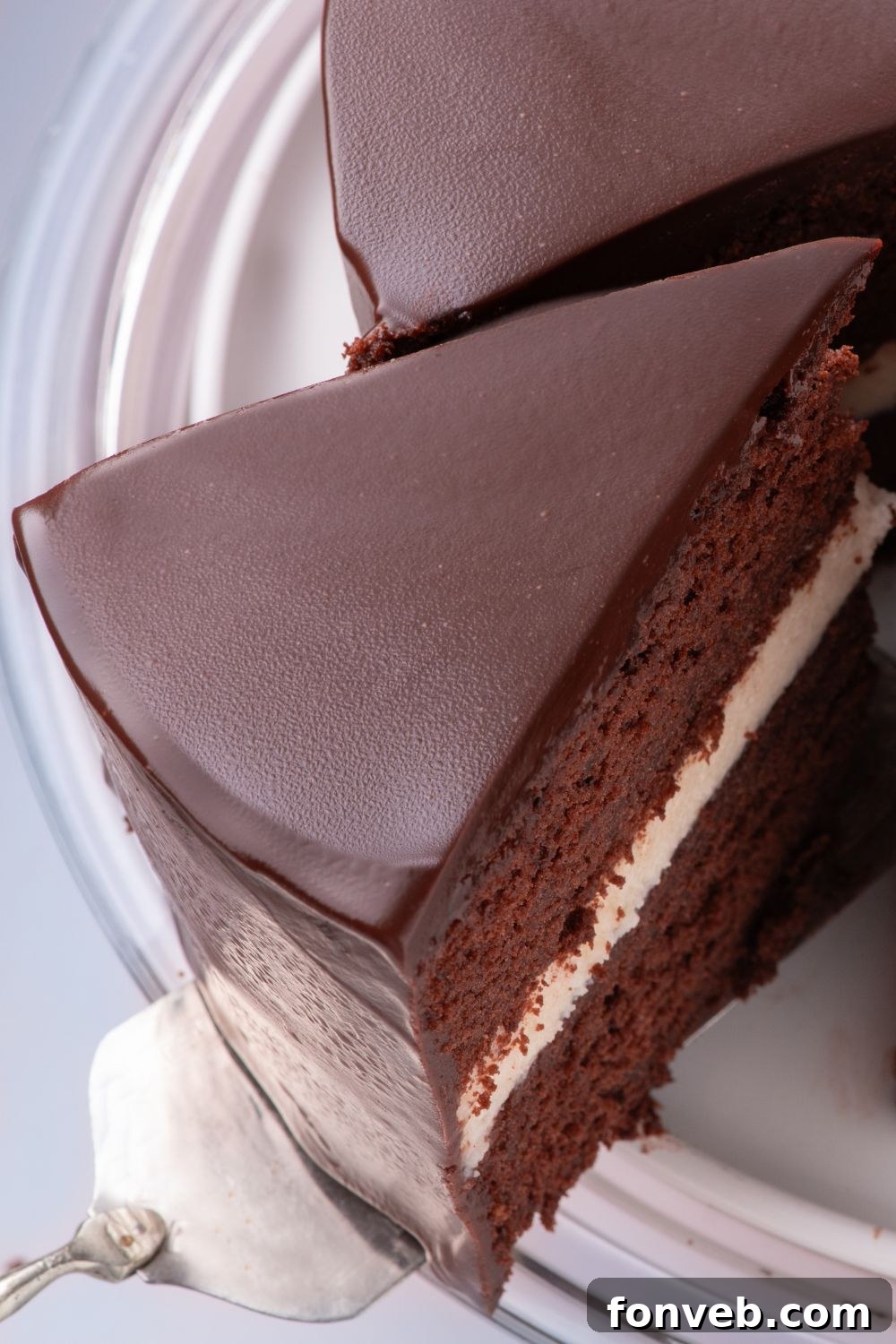 Decadent Chocolate Cream Dream 23 A homemade Hostess Ding Dong Cake on a plate, with a delicious slice being lifted out by a spatula, revealing its soft layers and creamy filling.