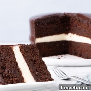 Decadent Chocolate Cream Dream 25 A delicious Ding Dong Cake on a table with a slice of cake on a plate, ready to be enjoyed.