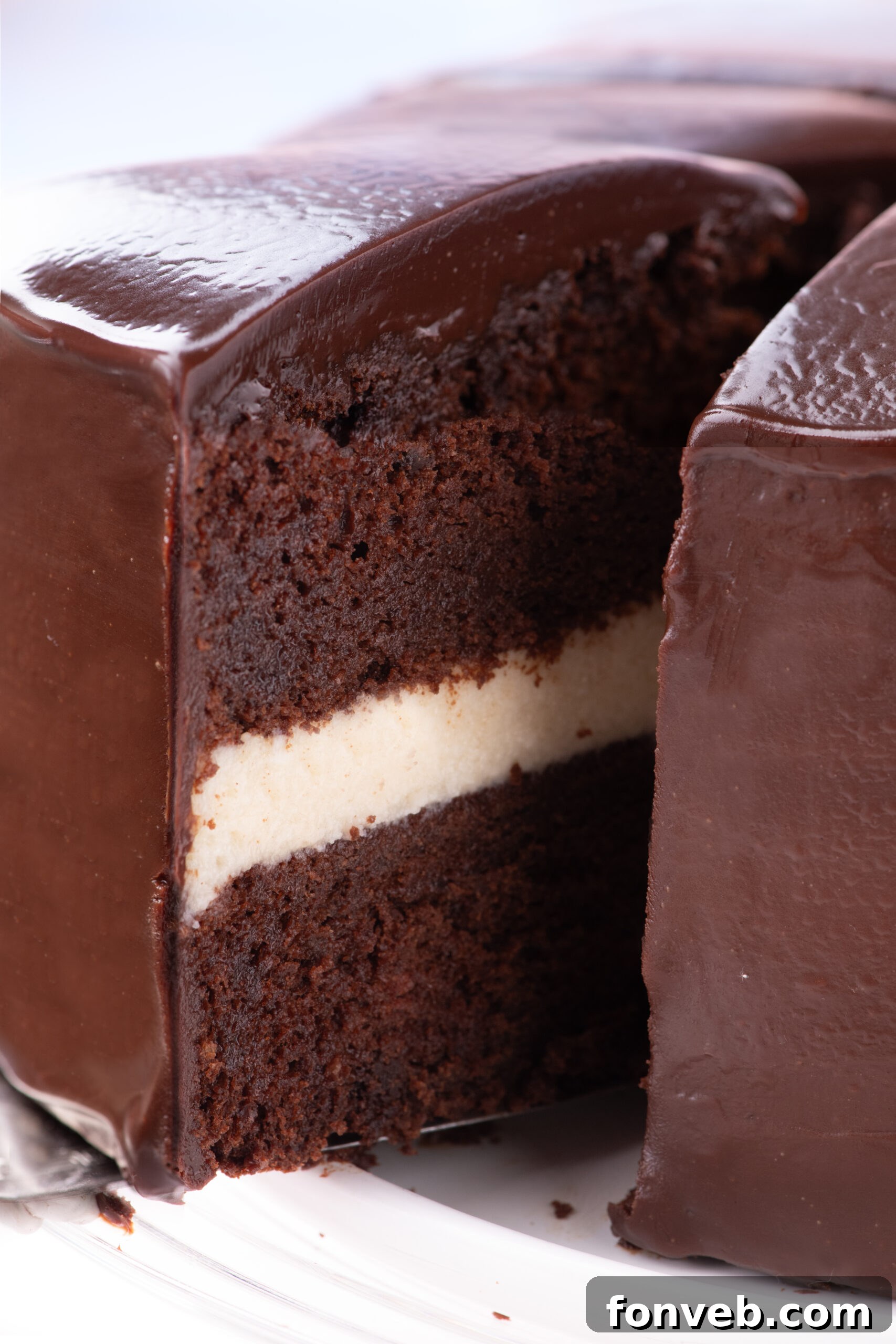 Decadent Chocolate Cream Dream 9 A mesmerizing shot capturing a slice of Ding Dong Cake being carefully lifted and removed from the larger cake, showcasing its structural integrity and inviting appearance.