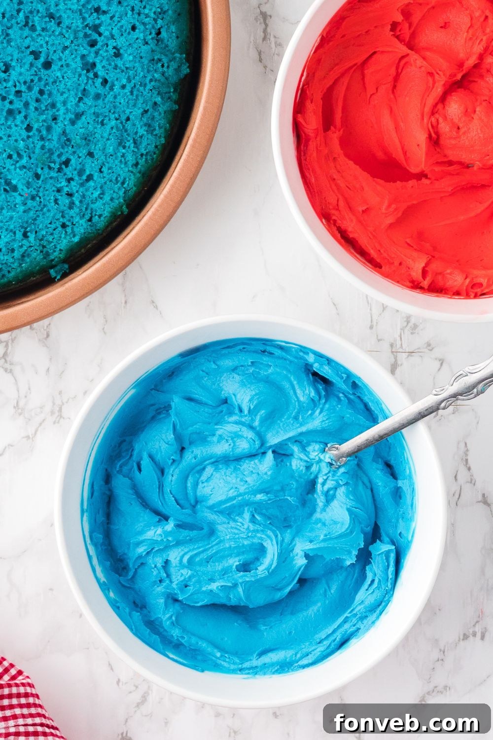 blue frosting in a bowl with spoon on table 