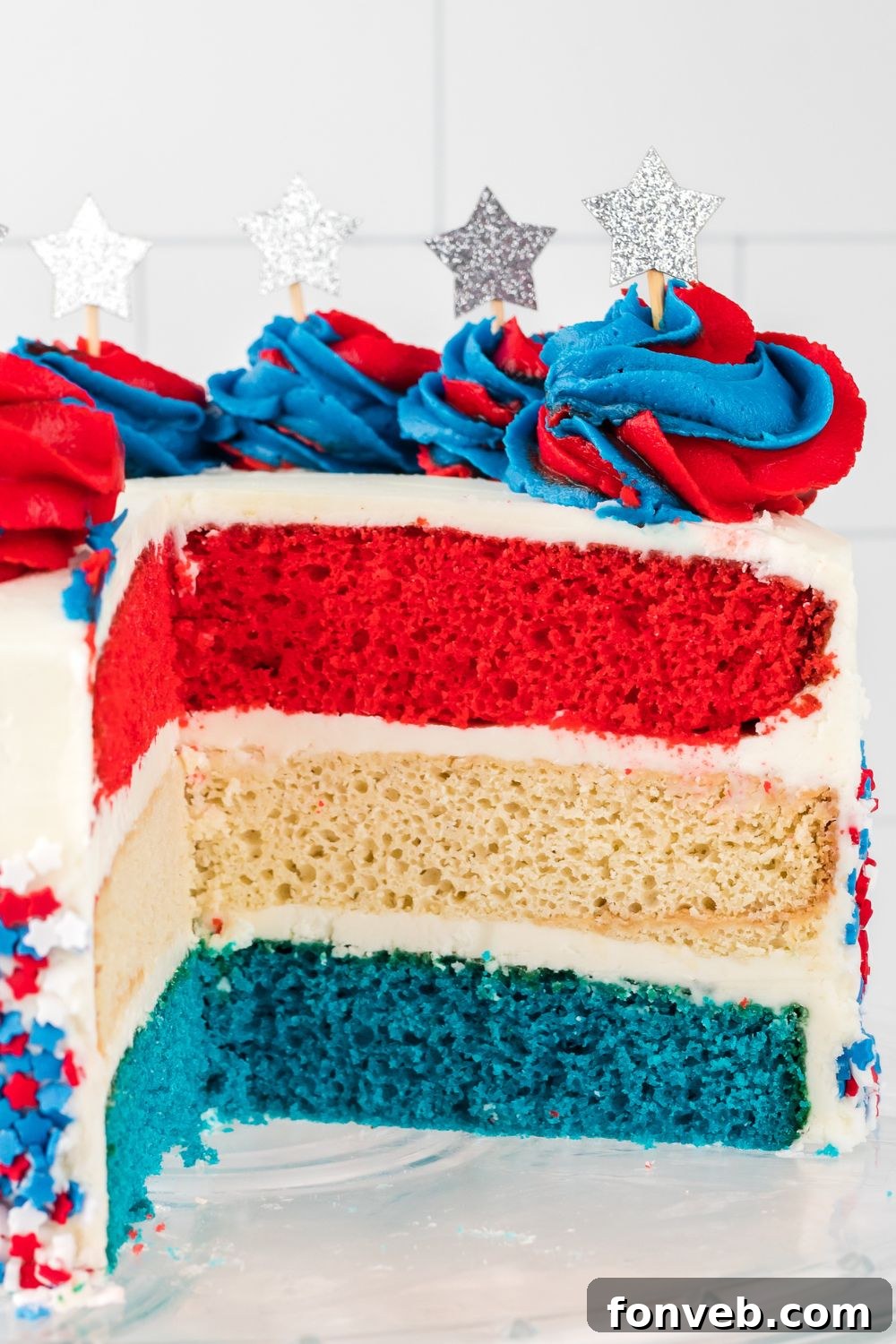 American Flag Cake cut open to see the colors of layers that is frosted 