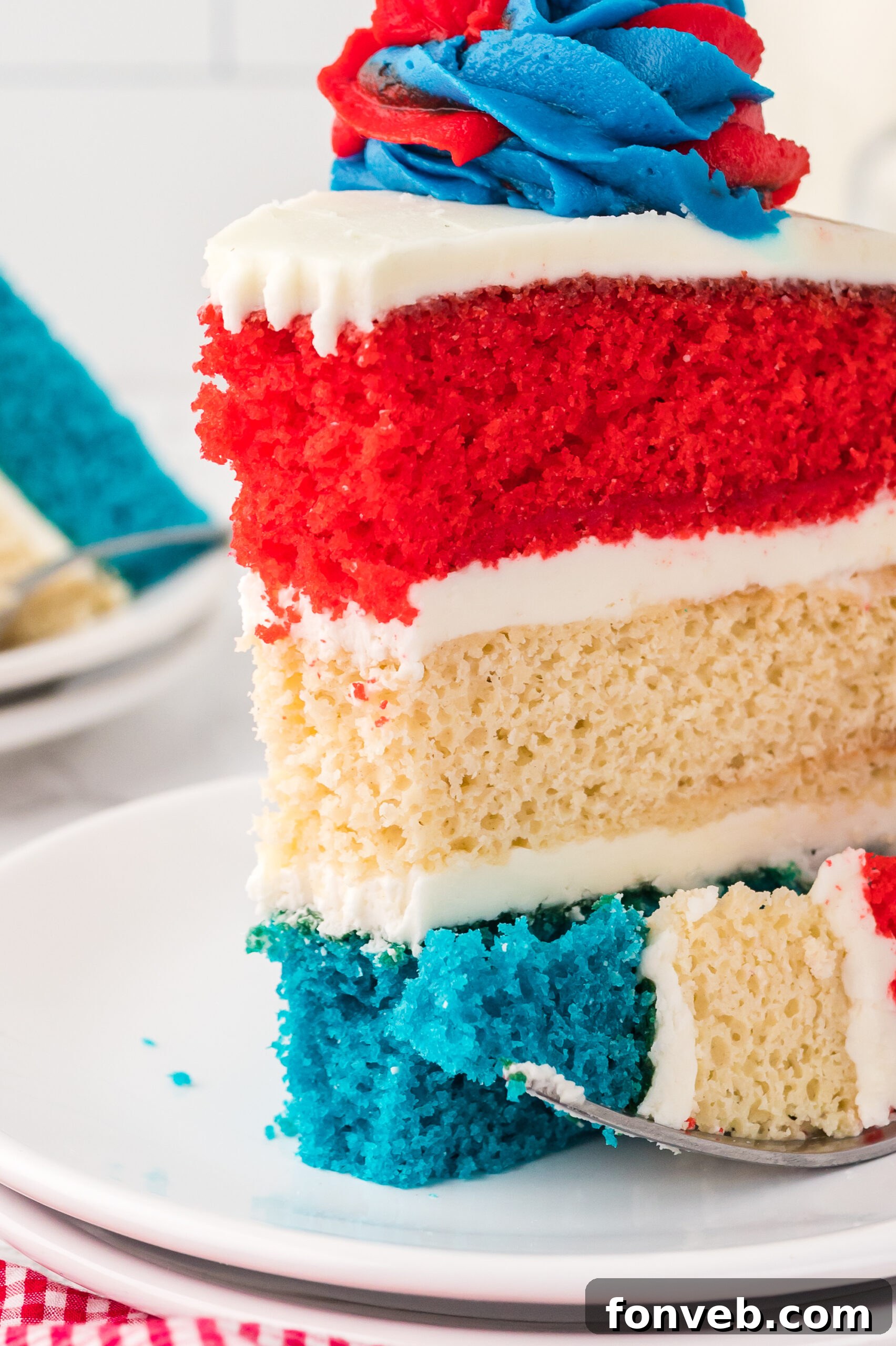 up close shot of a slice of American Flag Layered Cake on a white plate 