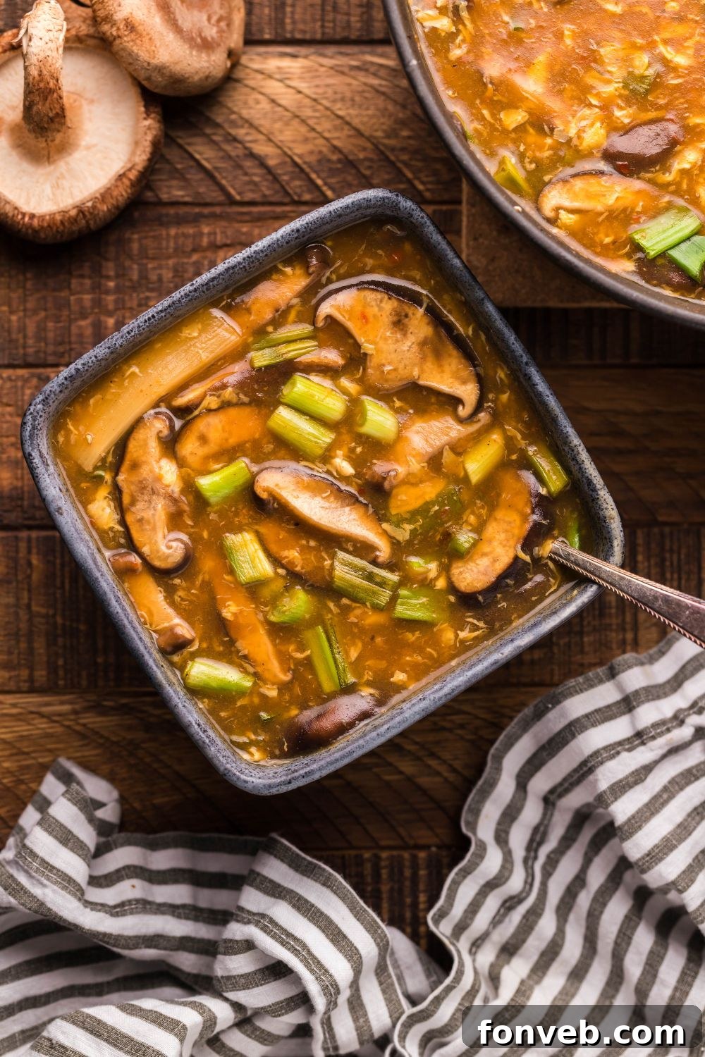 PF Chang's Fiery & Tangy Soup 13 PF Changs Hot And Sour Soup in a bowl with mushrooms on table, towel, and another bowl of soup