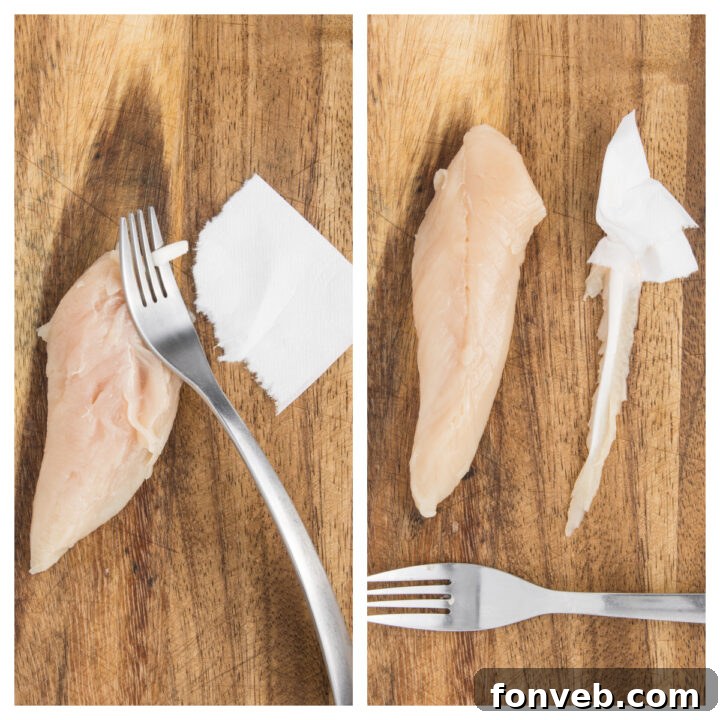 Ultra Crispy Air Fryer Chicken Tenders 6 Demonstration of removing the tendon from a raw Air Fryer Chicken Tender using a fork and paper towel