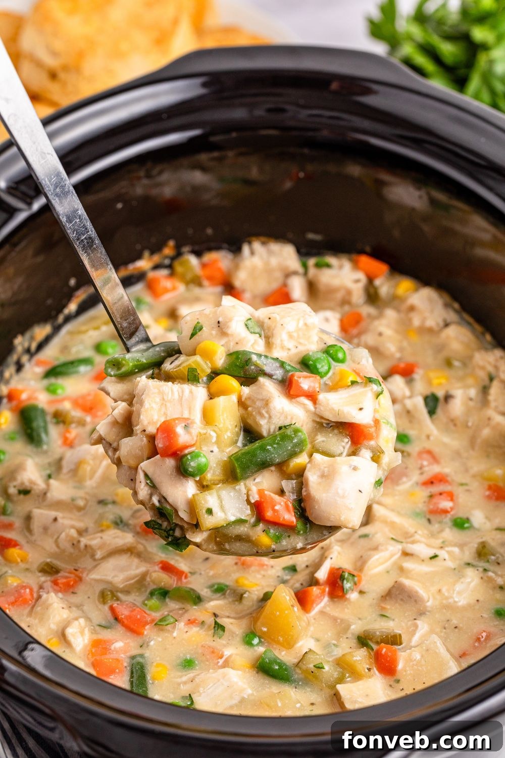 Easy Slow Cooker Chicken Pot Pie 15 ladle of chicken pot pie mixture in slow cooker being lifted out of slow cooker