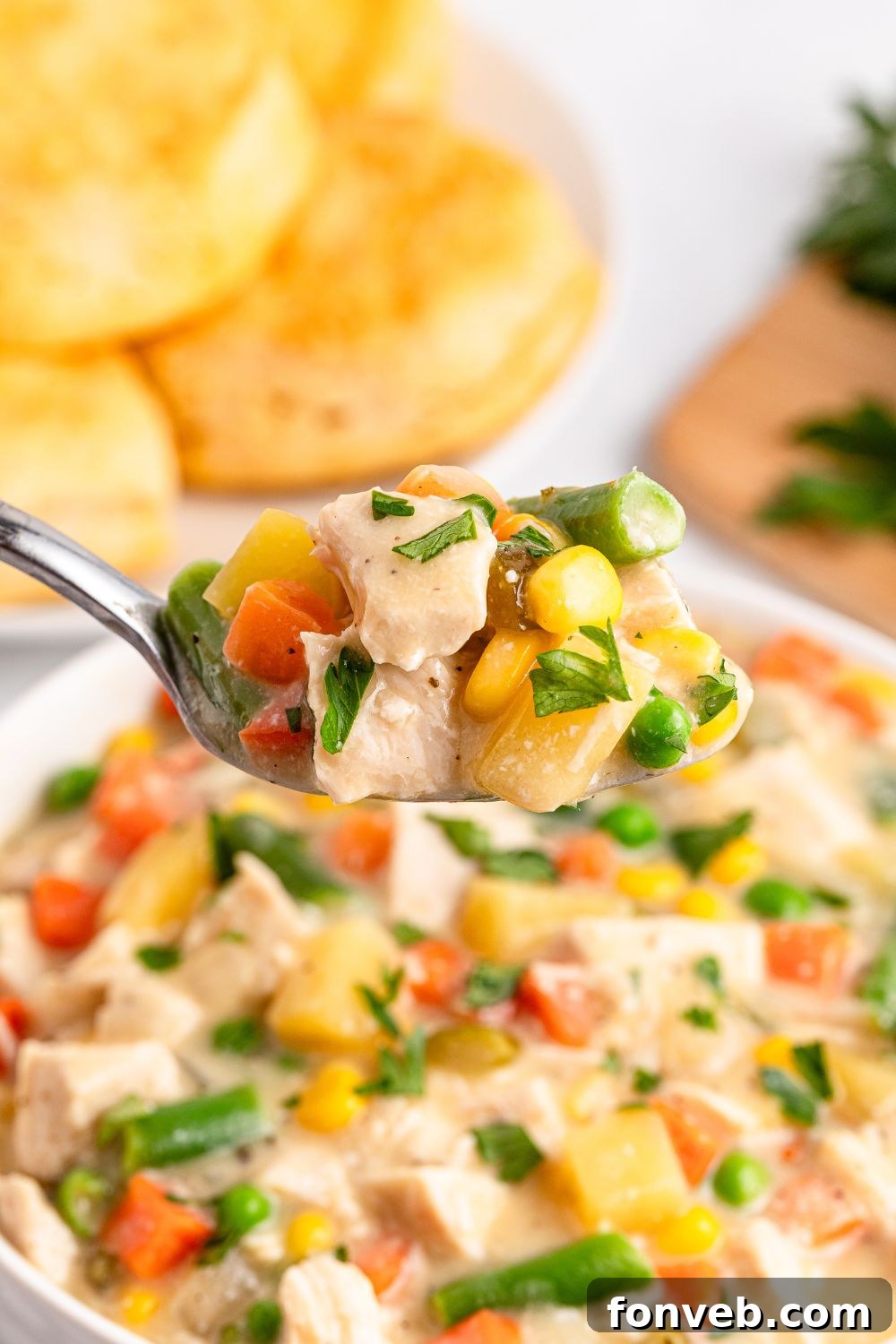 Easy Slow Cooker Chicken Pot Pie 16 Slow Cooker Chicken Pot Pie in a bowl with a spoon scooping out of it