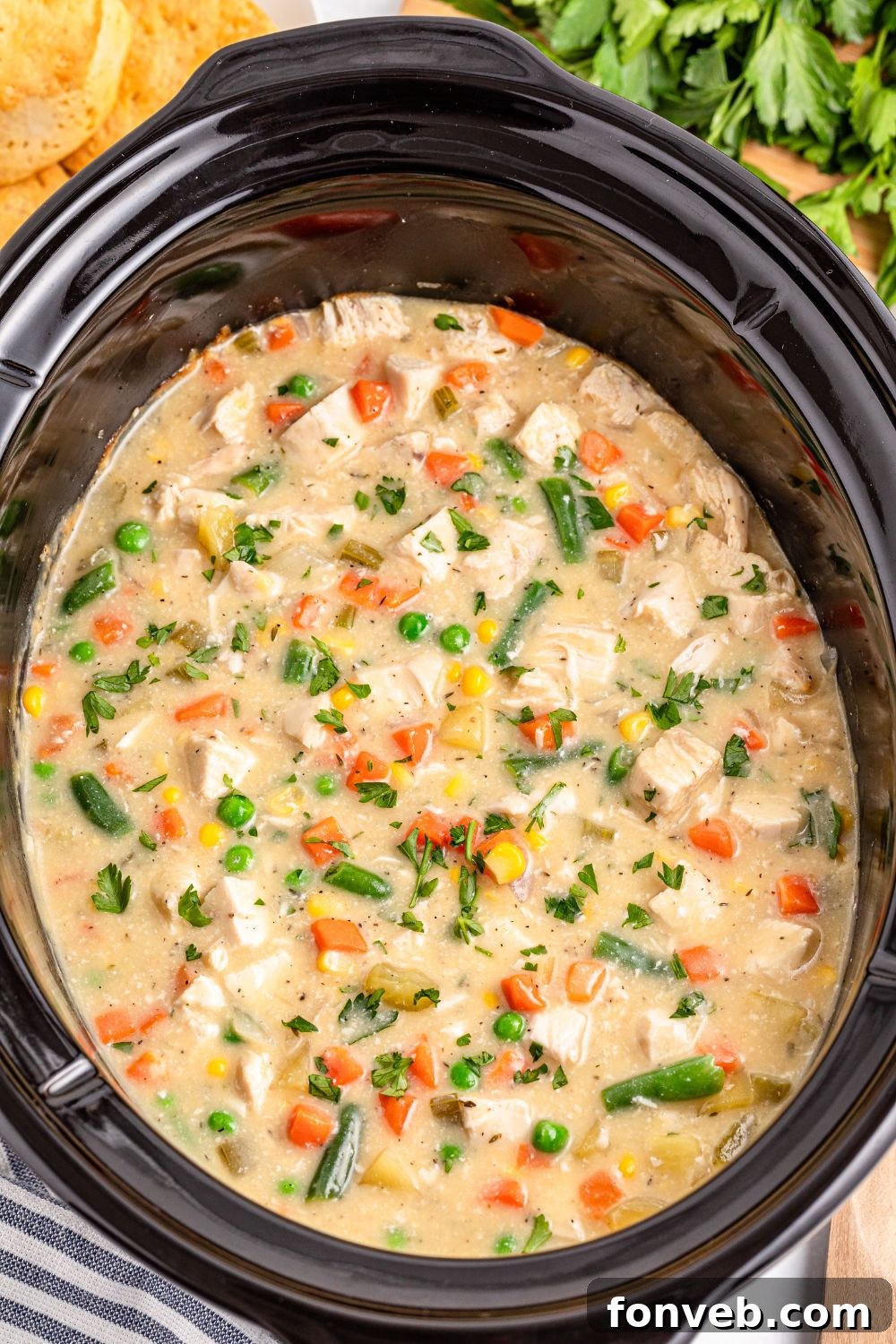 Easy Slow Cooker Chicken Pot Pie 18 Slow Cooker Chicken Pot Pie in a slow cooker sitting on table with a towel on side