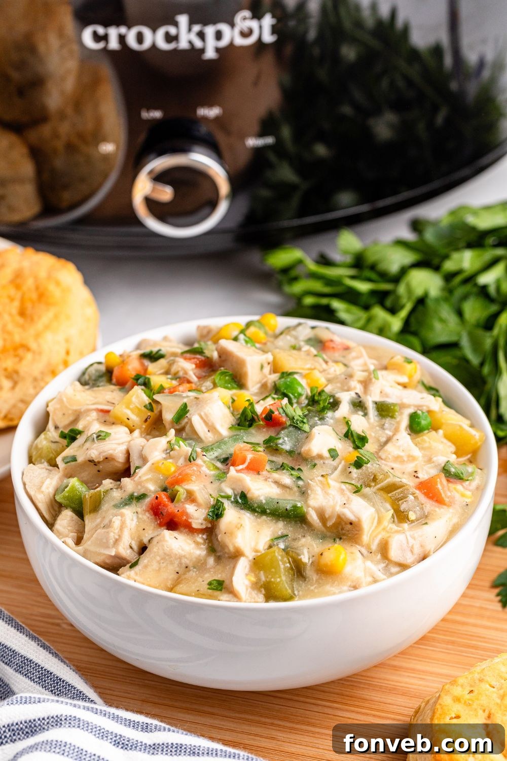 Easy Slow Cooker Chicken Pot Pie 19 Slow Cooker Chicken Pot Pie in a bowl with a slow cooker behind it on table