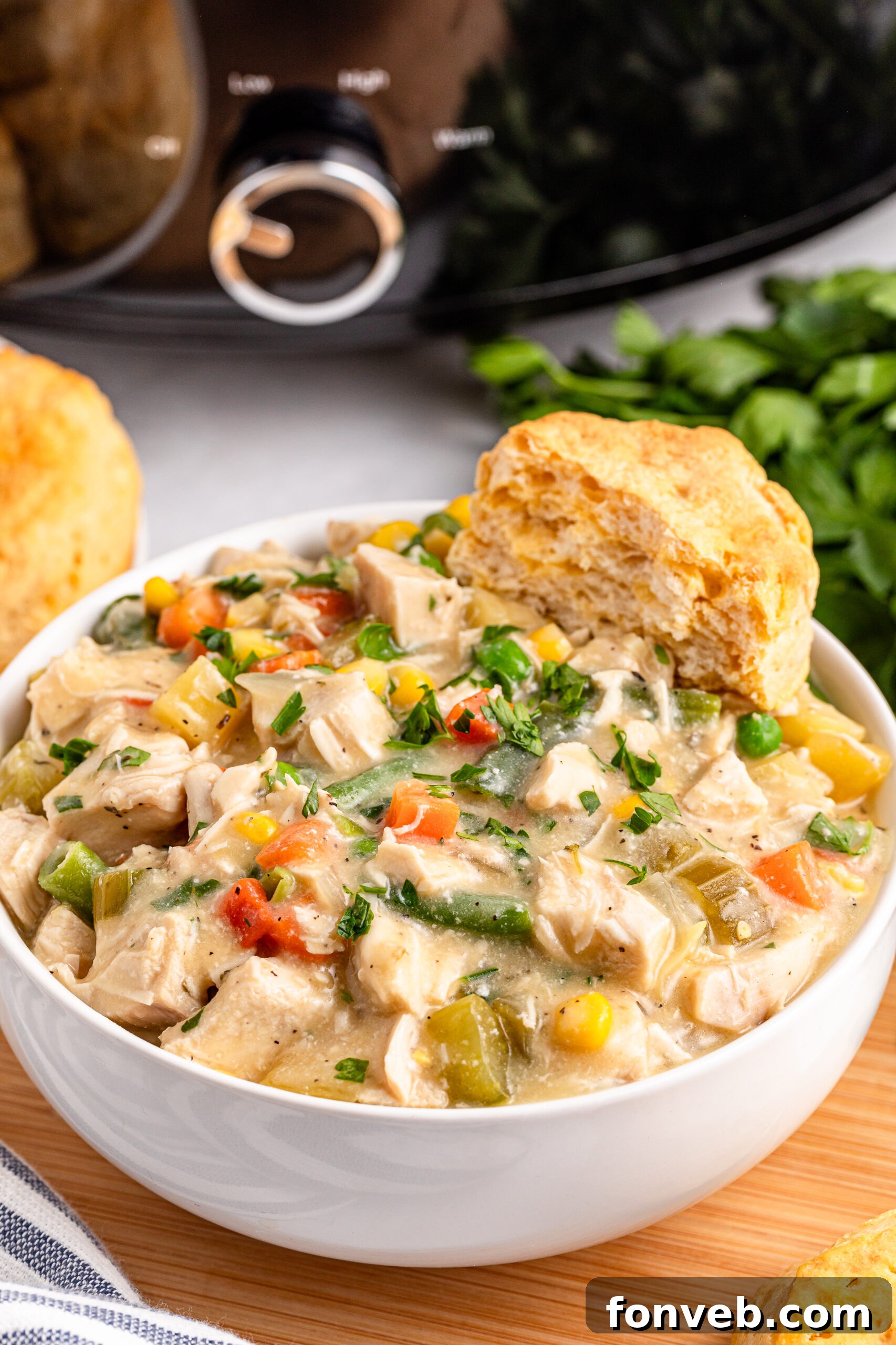 Easy Slow Cooker Chicken Pot Pie 3 white bowl filled with Slow Cooker Chicken Pot Pie with a biscuit on the side