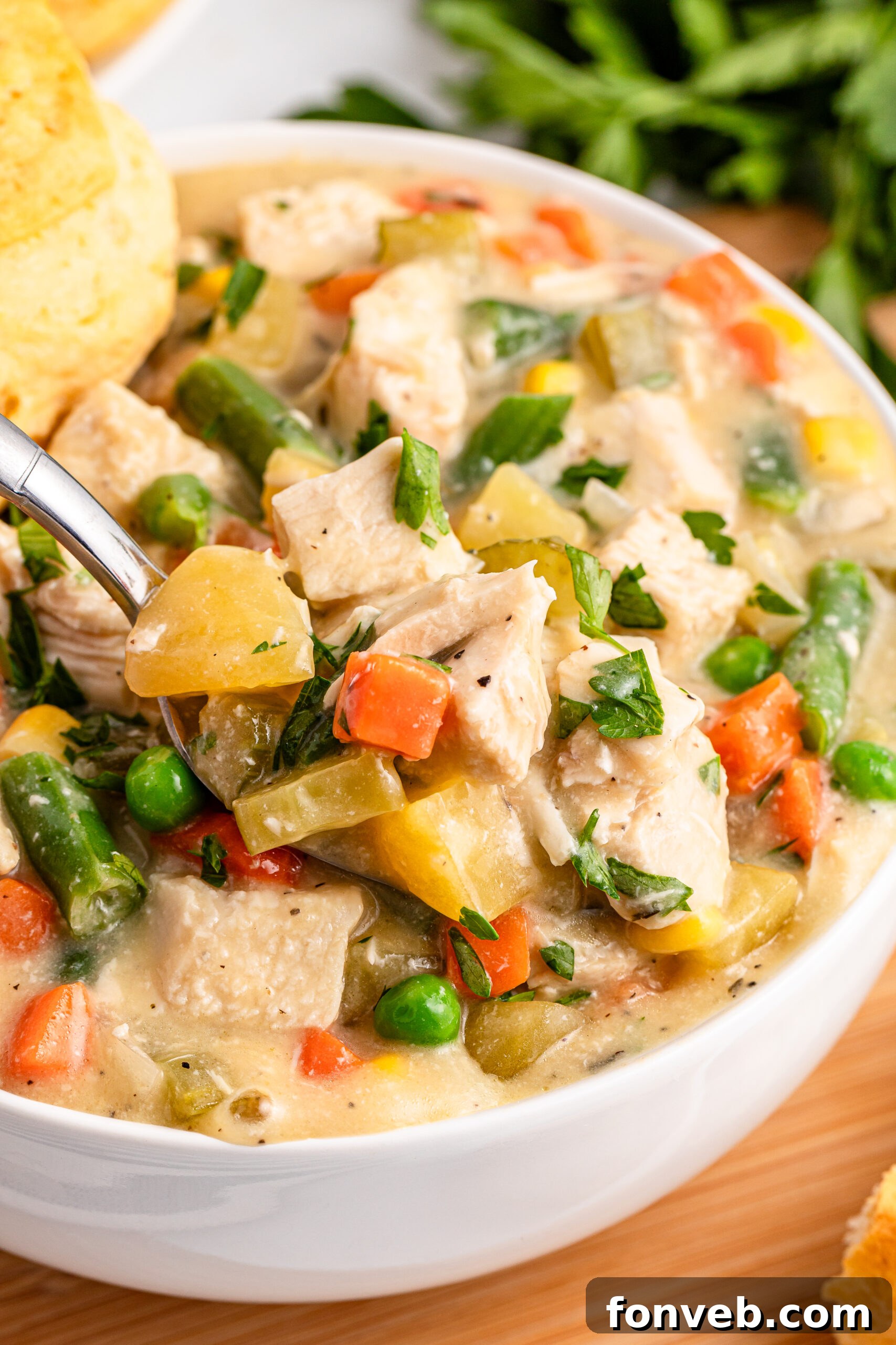 Easy Slow Cooker Chicken Pot Pie 4 up close shot of the Slow Cooker Chicken Pot Pie in a white bowl with a spoon lifting up some