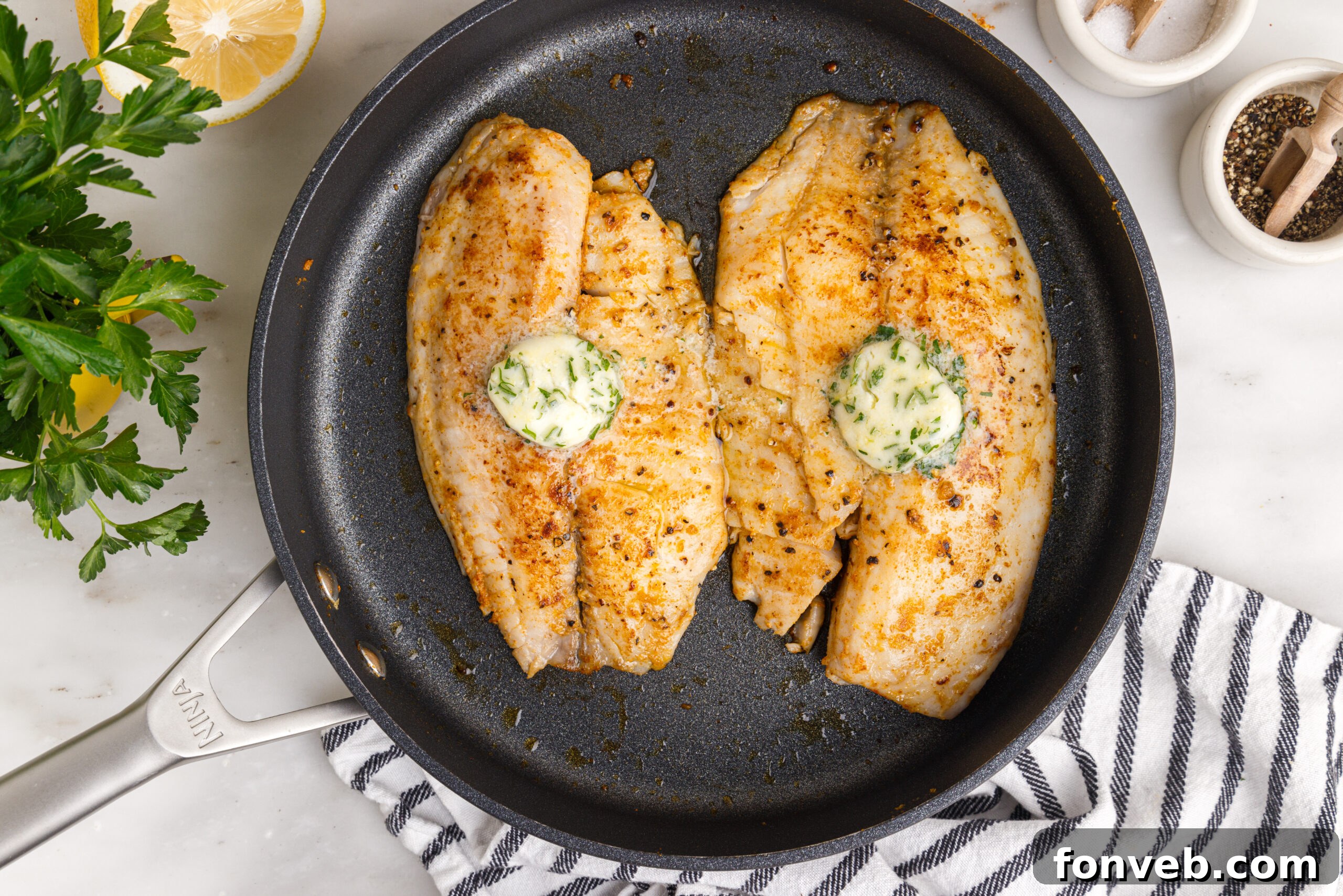 Golden Pan-Seared Tilapia 11 overhead shot of the Pan Fried Tilapia in a skillet up close topped with butter