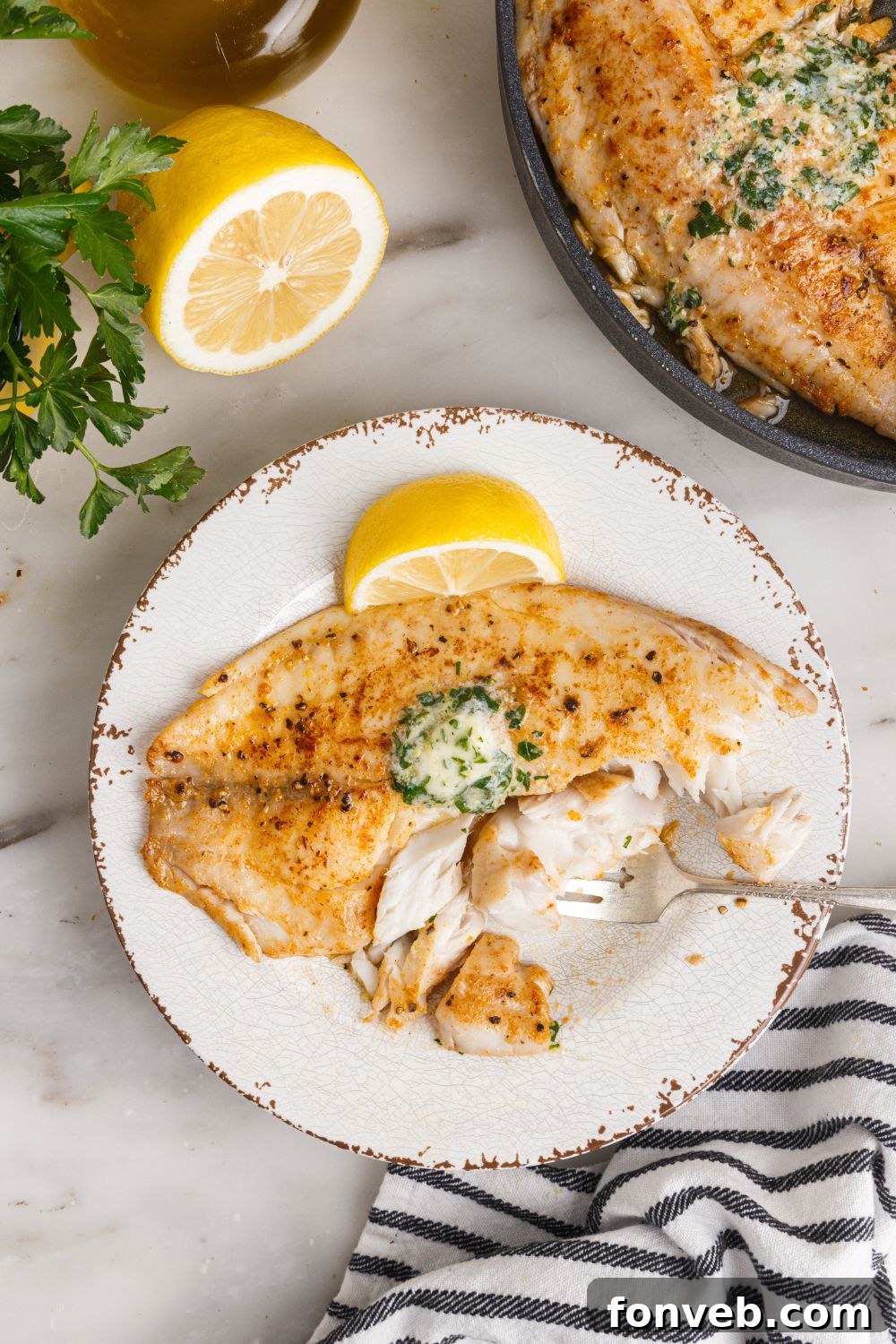 Golden Pan-Seared Tilapia 13 Pan Fried Tilapia on plate with pan of fish to side and lemons to showcase on side of plate