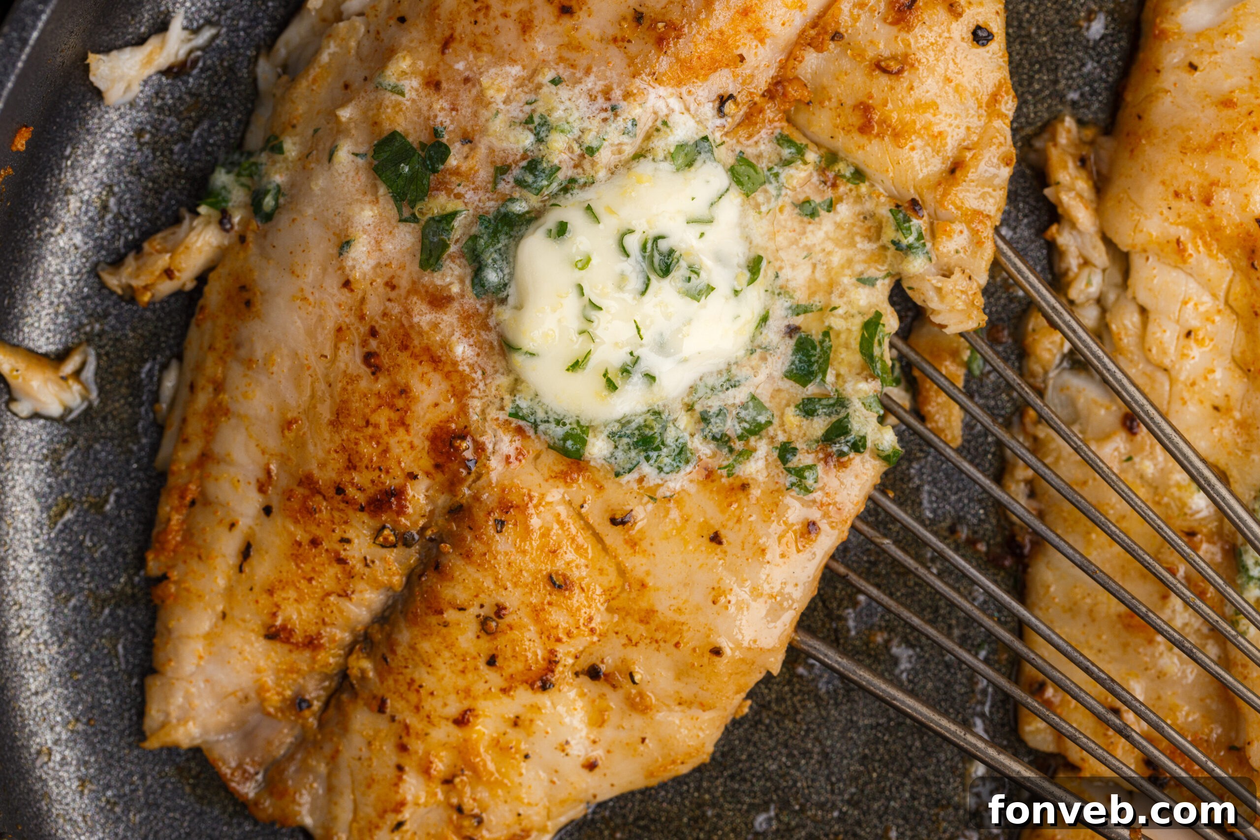 Golden Pan-Seared Tilapia 14 Pan Fried Tilapia in a skillet up close topped with butter