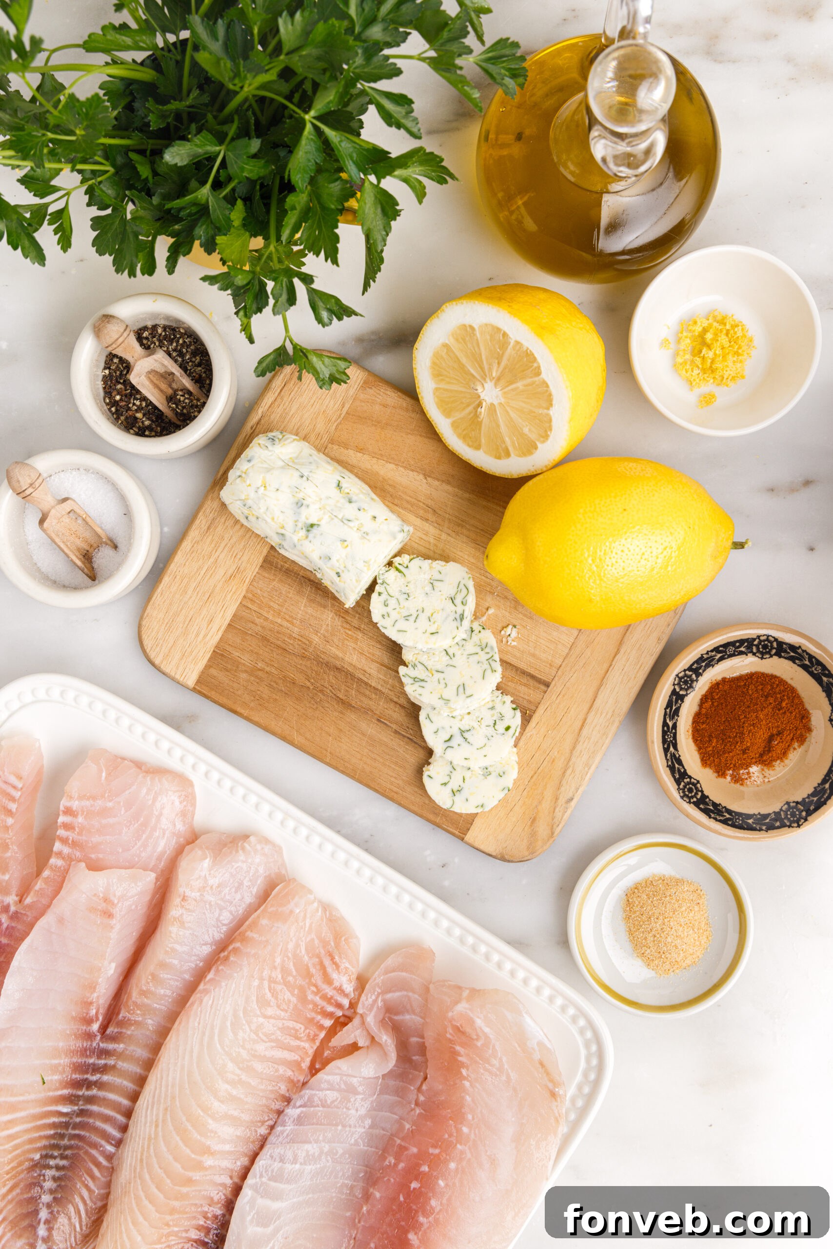 Golden Pan-Seared Tilapia 5 Pan fried tilapia ingredients on a white marble table laid out