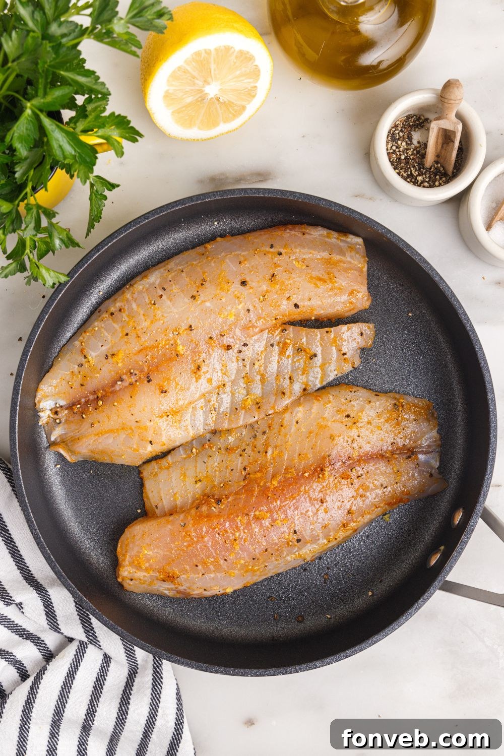 Golden Pan-Seared Tilapia 7 seasoned tilapia in pan, raw.