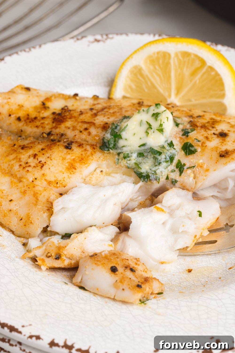 Golden Pan-Seared Tilapia 10 Pan Fried Tilapia on plate with pieces cut out of it