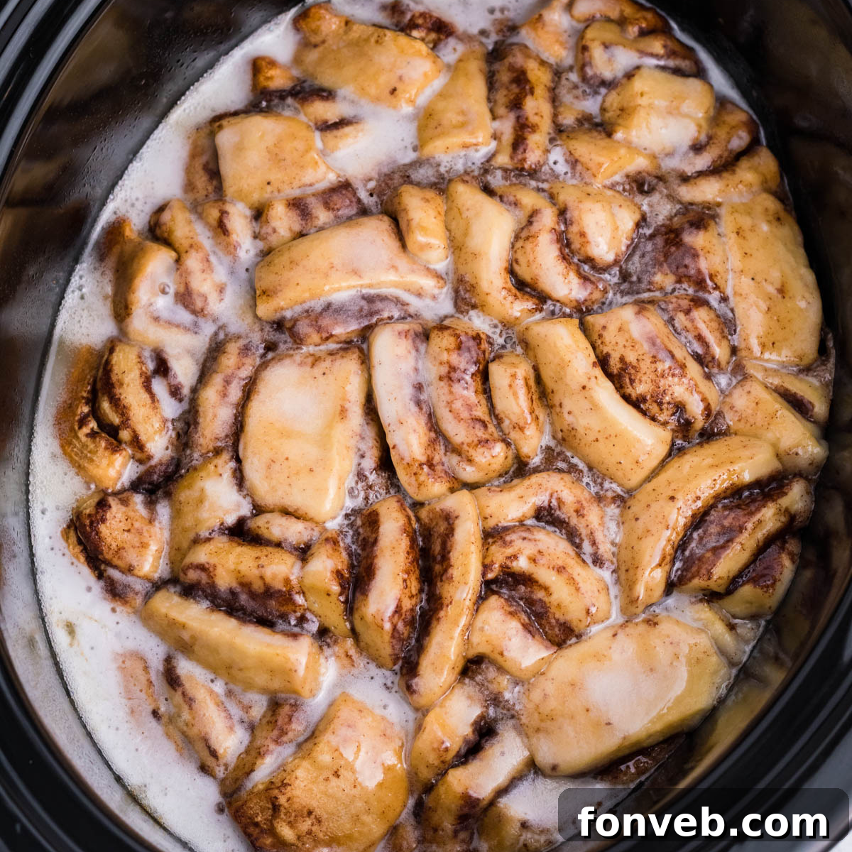 Overhead view of Crock Pot Cinnamon Roll Casserole in a black crock pot insert