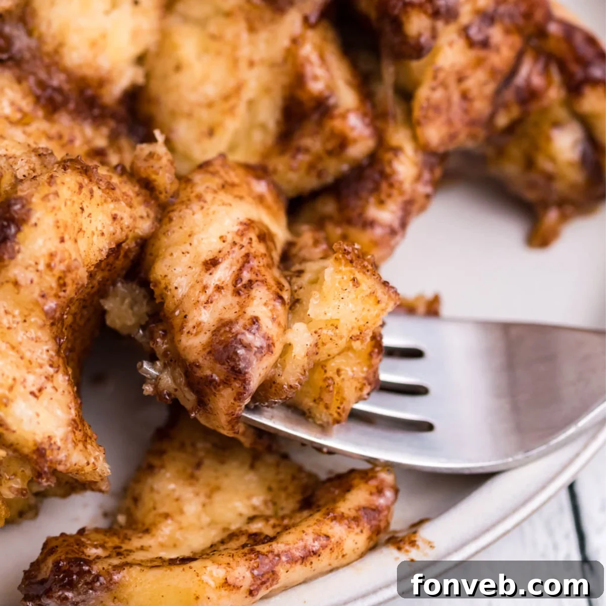 Up close shot of a piece of  Cinnamon Roll Casserole on a silver fork. 