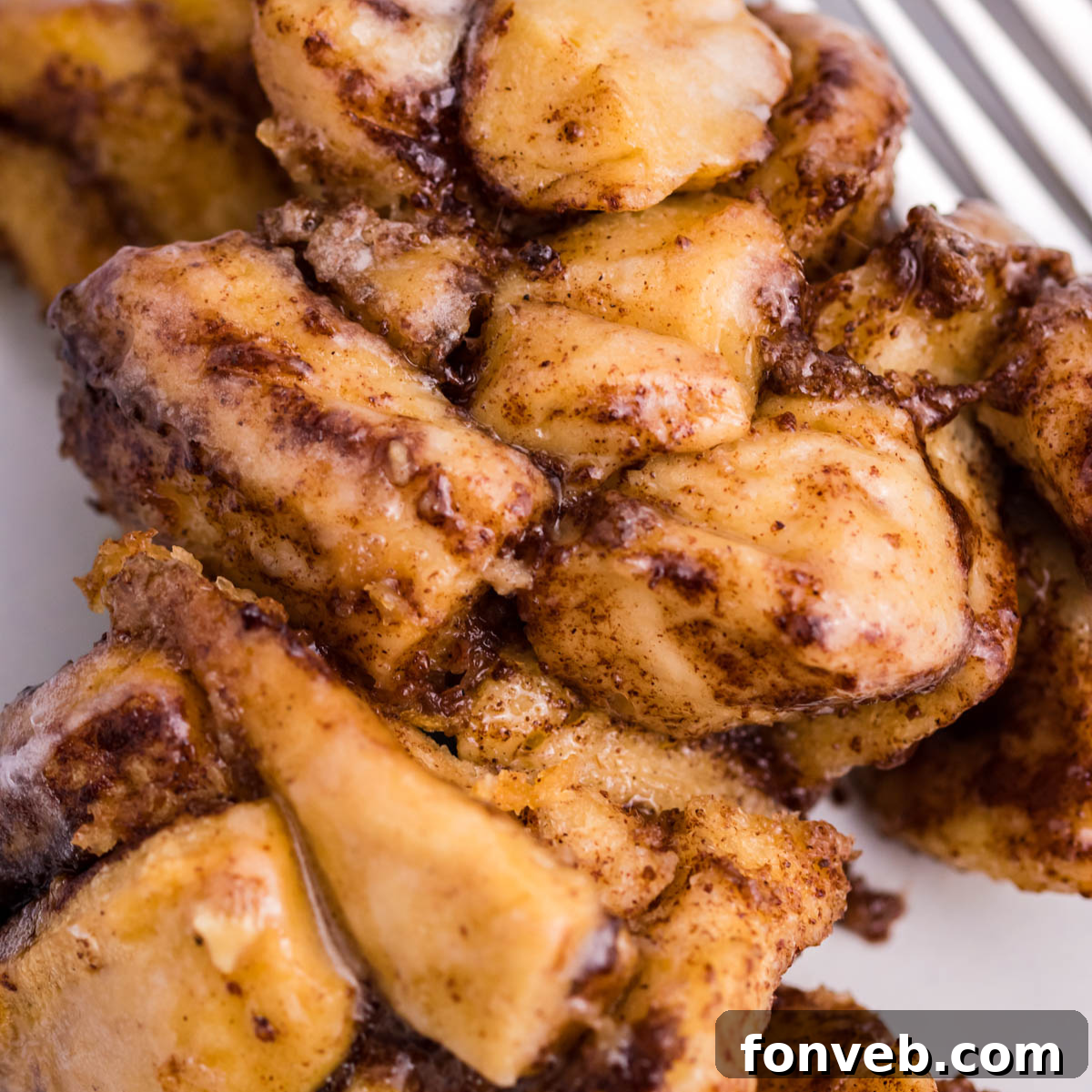 Up close view of the cinnamon sugar on the casserole on a white plate.