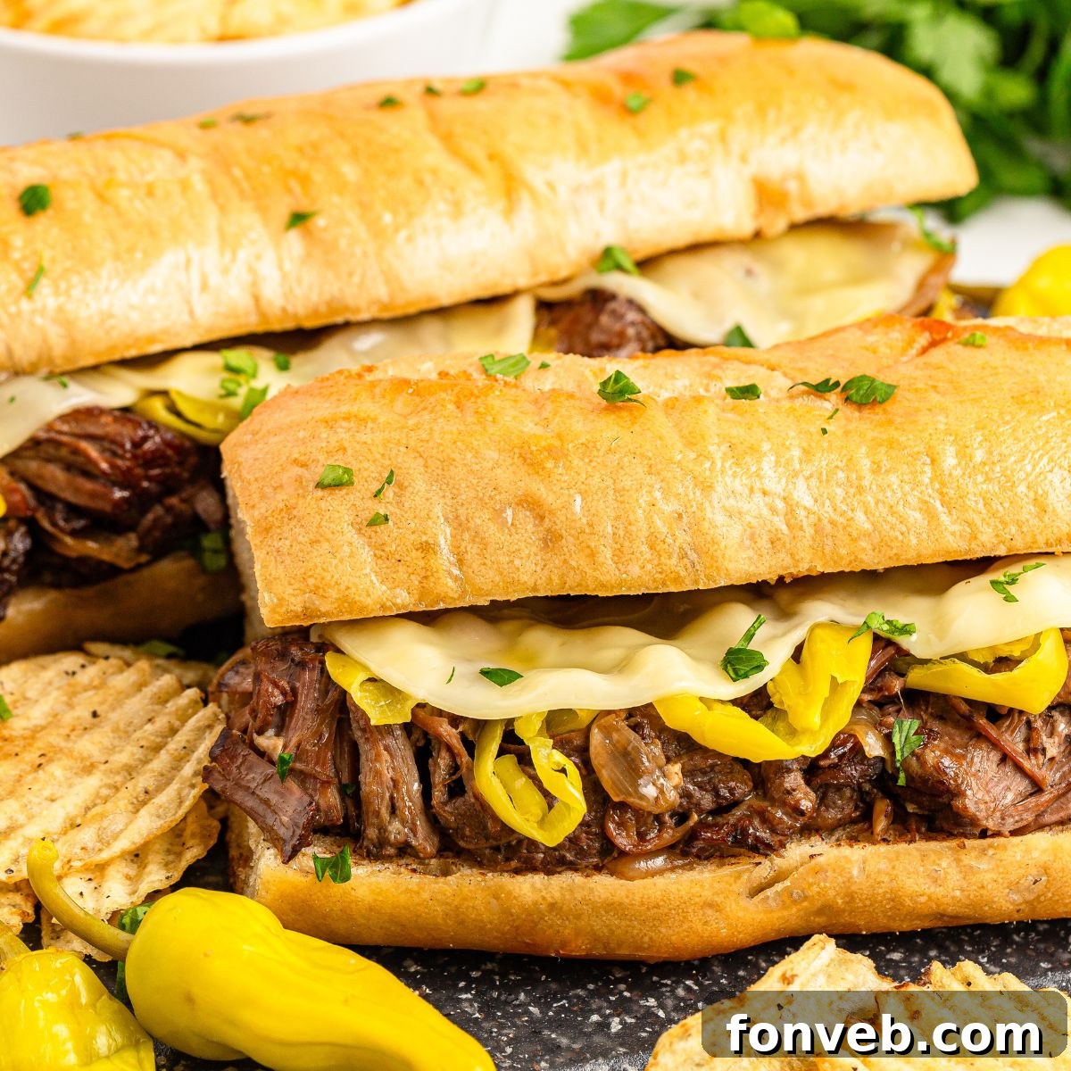 Ultimate Mississippi Pot Roast Sandwiches 2 Mississippi Pot Roast Sandwiches on table with chips on the side