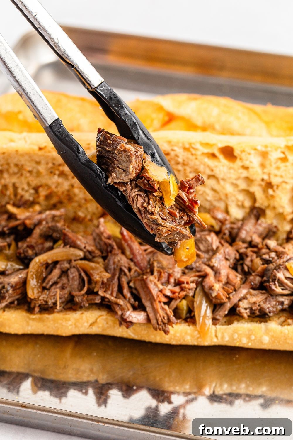 Ultimate Mississippi Pot Roast Sandwiches 15 Mississippi Pot Roast Sandwich with tongs putting more meat in sandwich