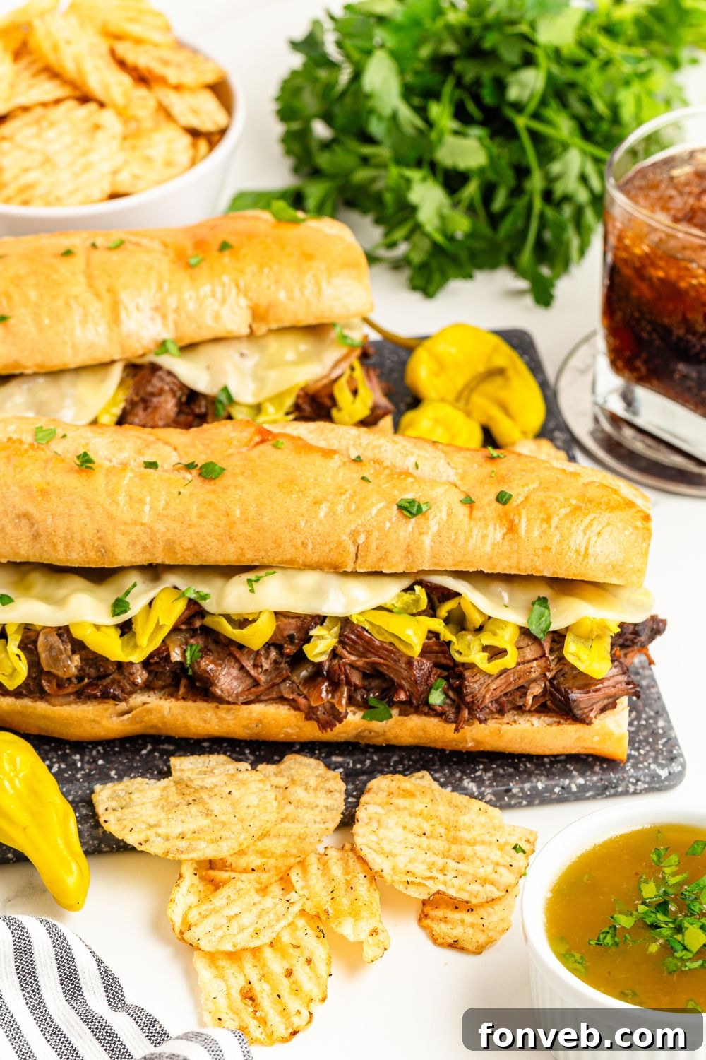 Ultimate Mississippi Pot Roast Sandwiches 8 Mississippi Pot Roast Sandwiches on a plate with chips, parsley, and drink to the side