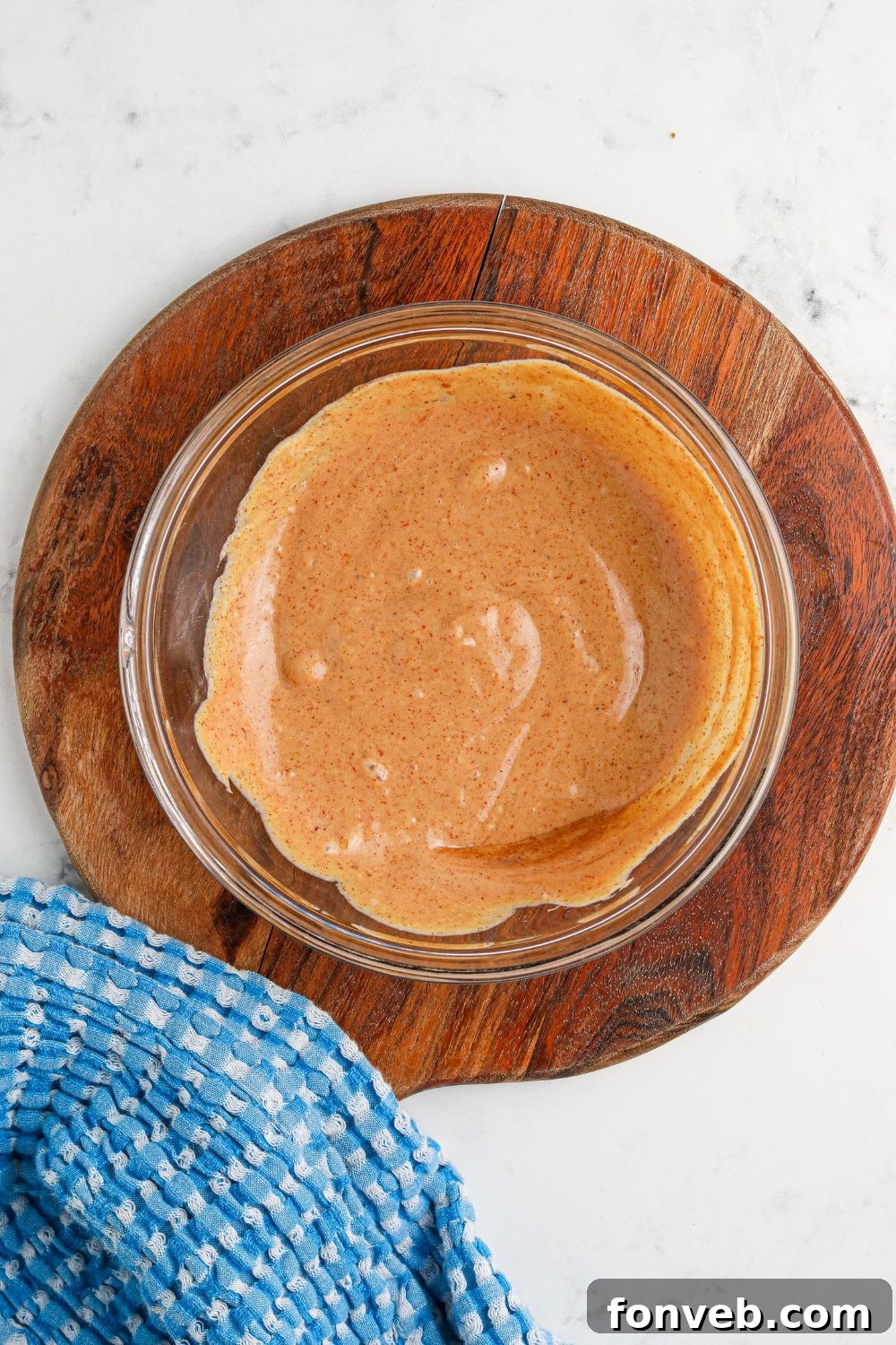 Chuck Wagon Burger 11 The Cowboy Burger sauce, perfectly mixed and creamy in a glass bowl, placed on a rustic wooden cutting board.