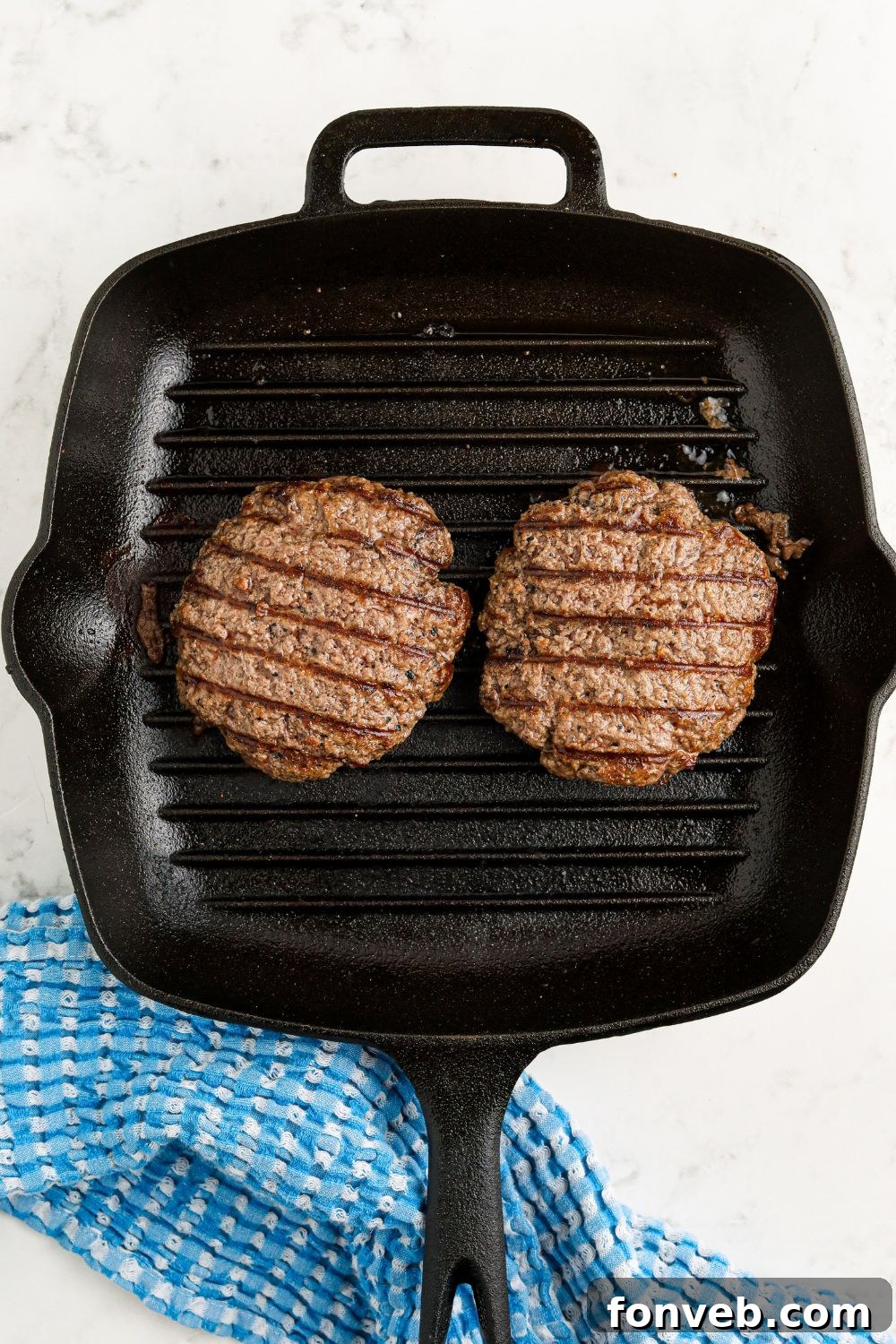 Chuck Wagon Burger 12 A grill pan filled with sizzling, perfectly cooked hamburger patties, ready for cheese and assembly.