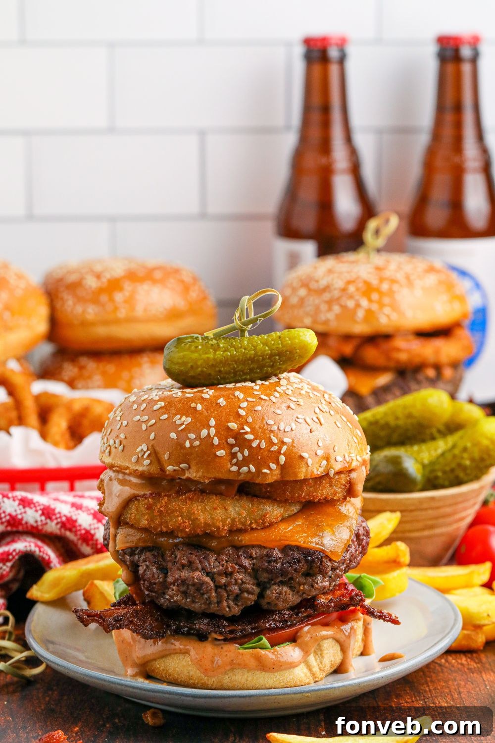 Chuck Wagon Burger 17 Several Cowboy Burgers arranged on a table, ready to be enjoyed, with blurred beer glasses and bottles in the background.