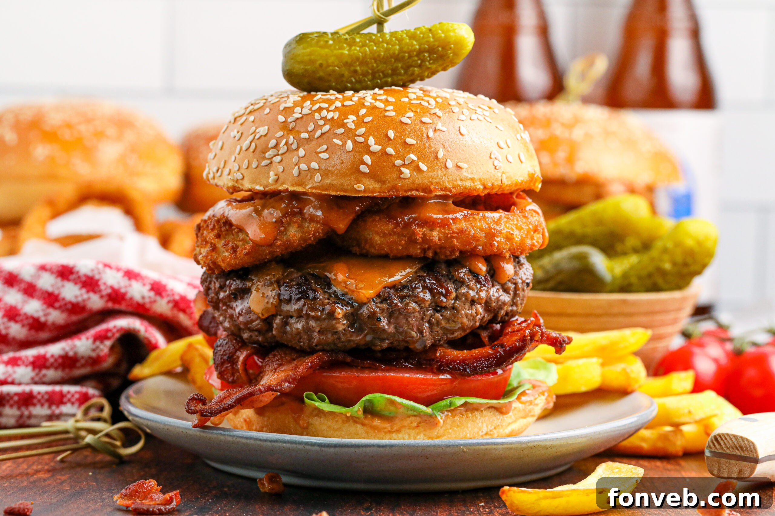 Chuck Wagon Burger 4 A side profile of a Cowboy Burger, highlighting its impressive height and stacked ingredients, served with fries and pickles.