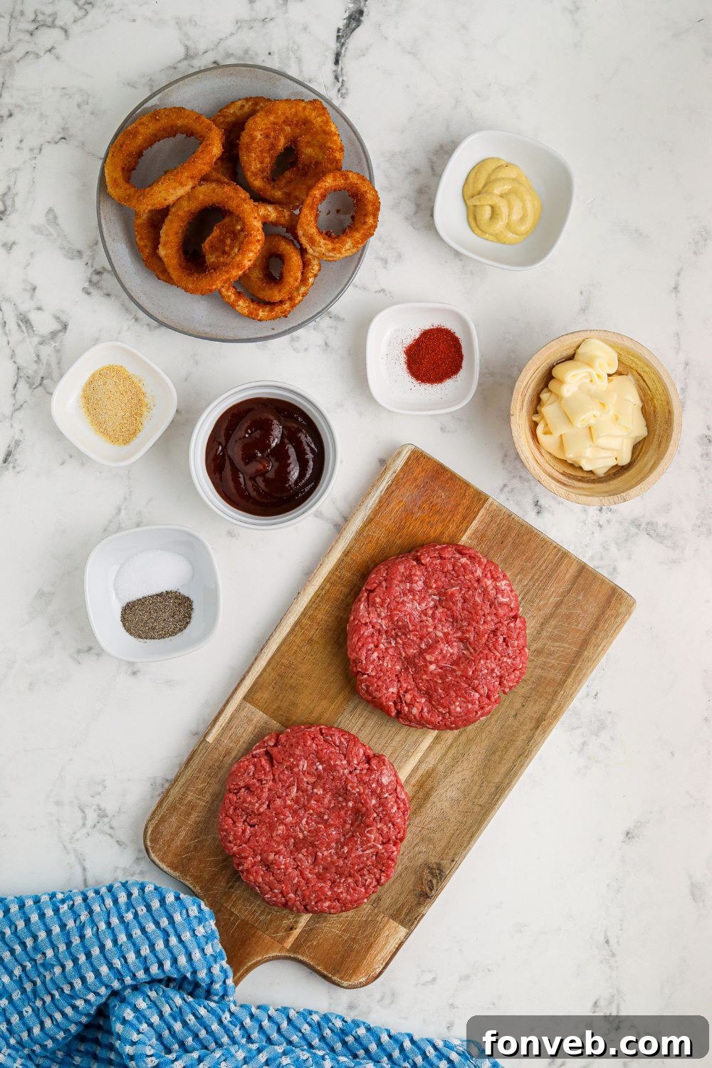 Chuck Wagon Burger 8 Individual ingredients for Cowboy Burgers, neatly arranged in small bowls on a table, ready for assembly.